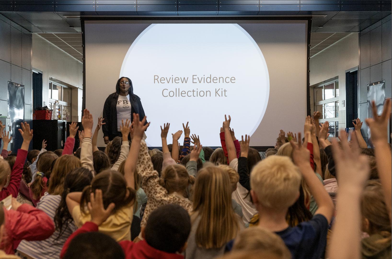 Michera Dobbs of the FBI speaks with second graders at Canyon Creek Elementary after an activity where the kids learned how to use detective skills in Farmington on Friday.
