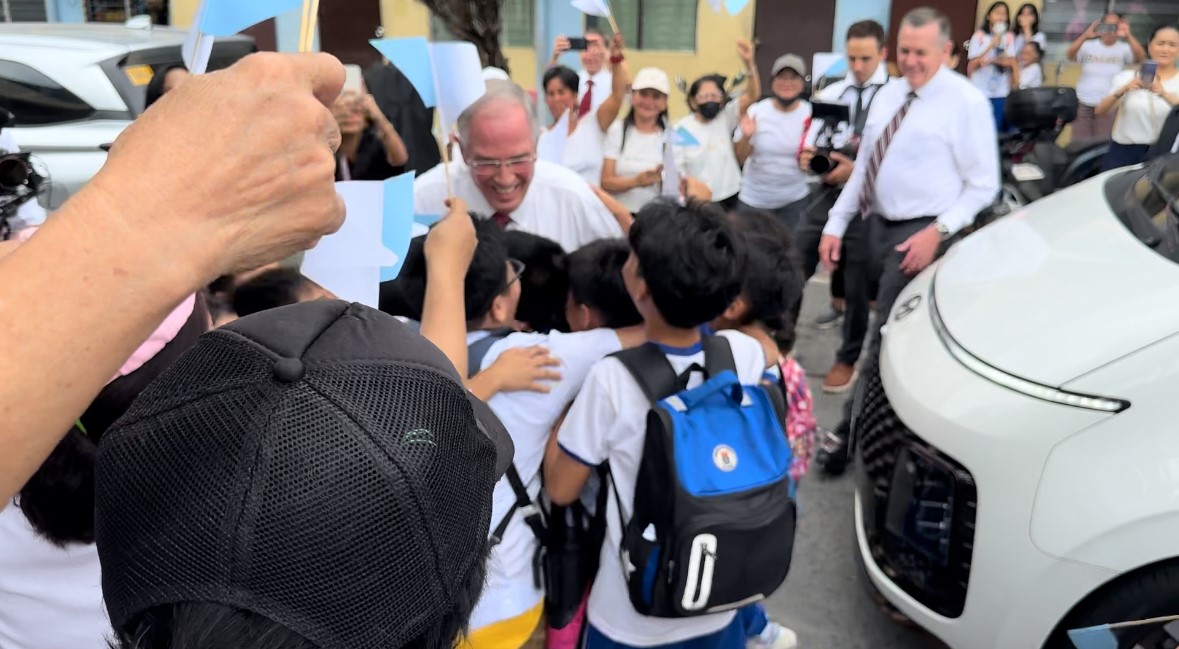 Community members gather around Elder Neil L. Andersen from the Quorum of the Twelve Apostles of The Church of Jesus Christ of Latter-day Saints and other church leaders during a visit on Thursday.