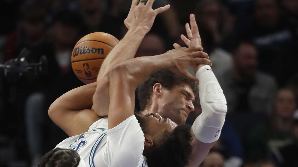 Milwaukee Bucks center Brook Lopez, rear, fouls Minnesota Timberwolves forward Karl-Anthony Towns during the first quarter of an NBA basketball game Friday, Feb. 23, 2024, in Minneapolis.