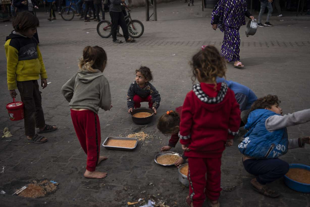 Palestinian kids receive free food in Rafah, Gaza Strip, Friday. An estimated 1.5 million Palestinians displaced by the war took refuge in Rafahor, which is likely Israel's next focus in its war against Hamas.