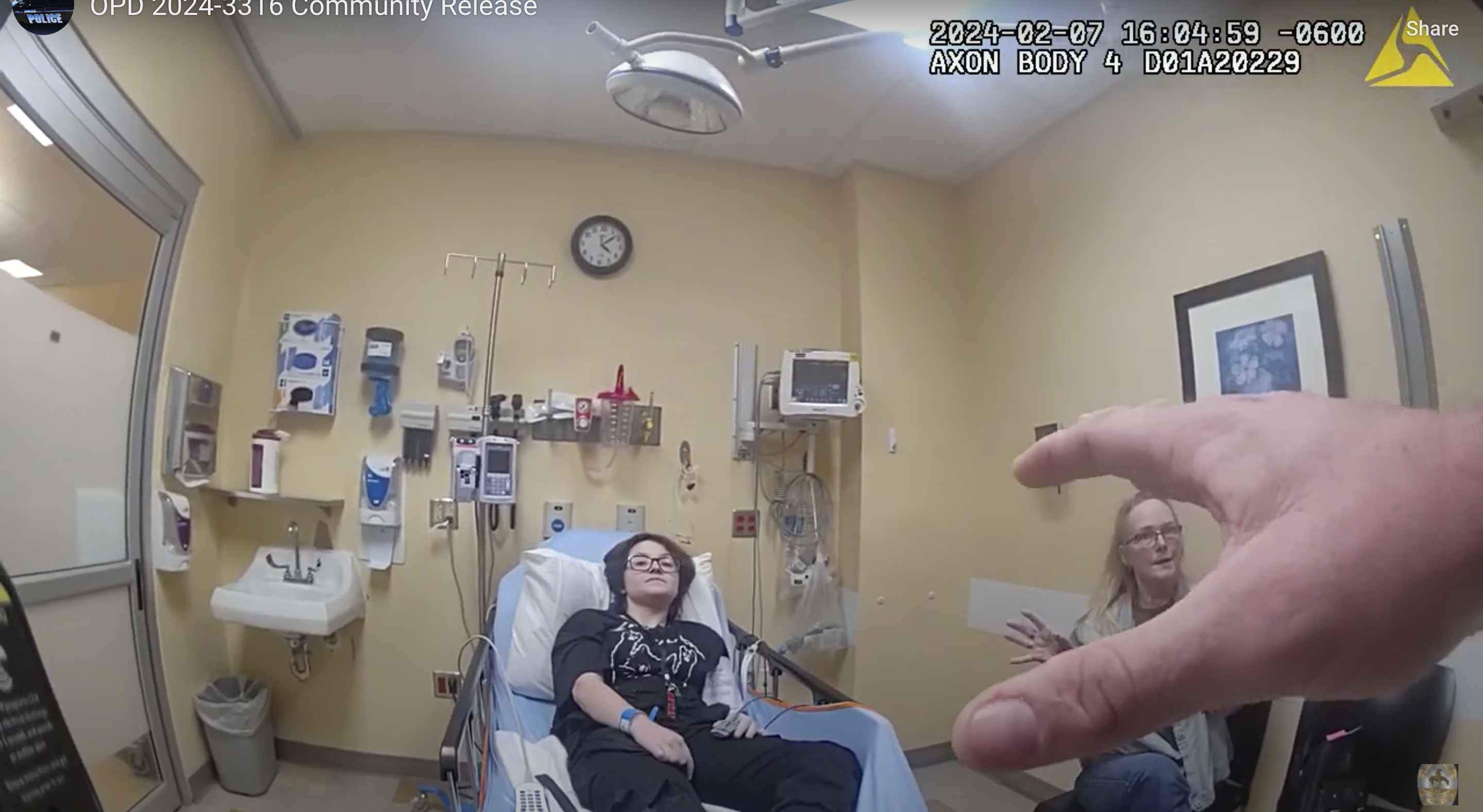 An officer speaks to 16-year-old Nex Benedict and their mother, Sue Benedict, at a hospital, Feb. 7. Sue says Nex was knocked to the floor during a fight in a school bathroom earlier in the day. Nex died the following day. 