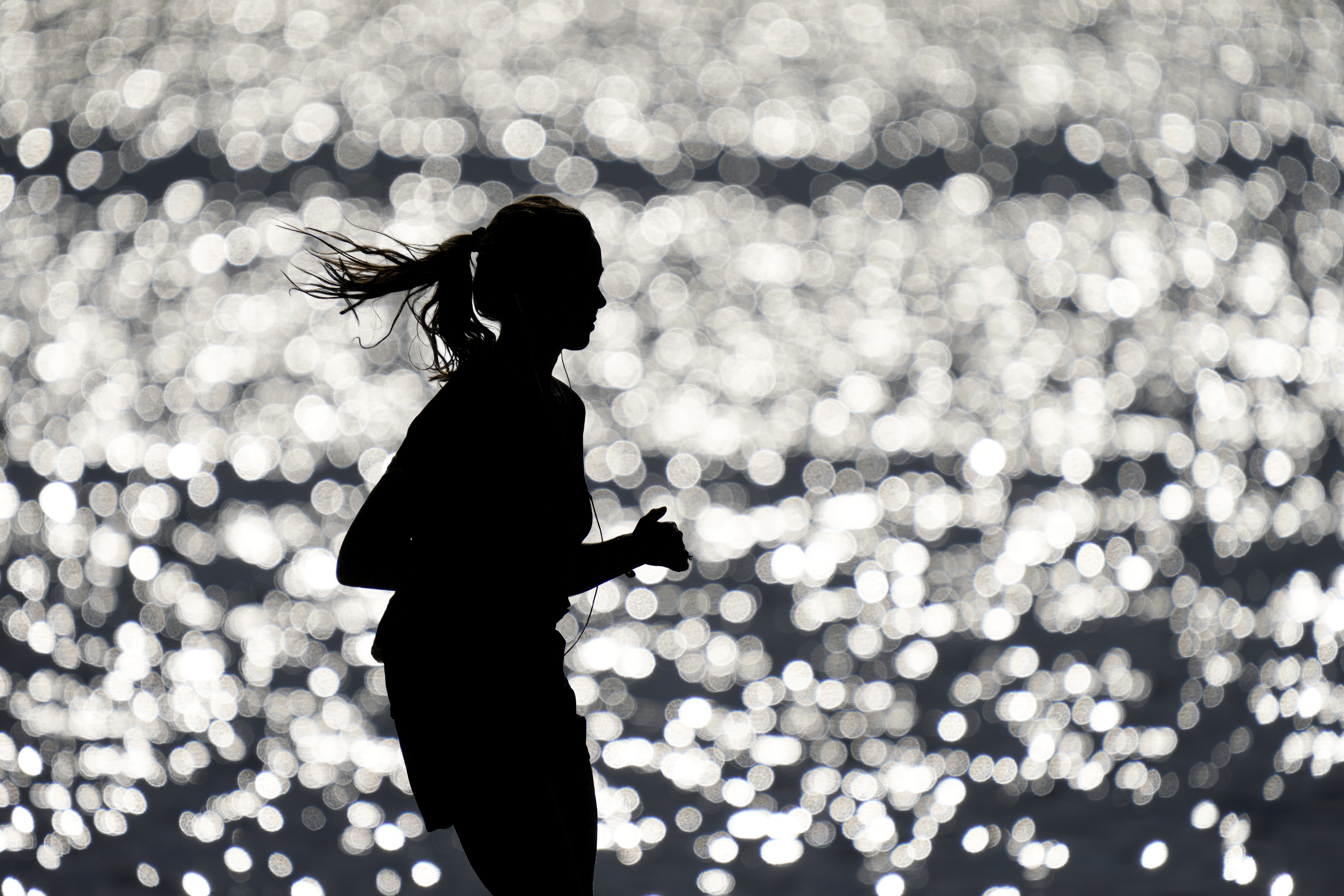FILE - A runner makes her way along the path at Gray's Lake Park, Friday, April 14, 2023, in Des Moines, Iowa. The killing of a 22-year-old nursing student has once again put the spotlight on dangers faced by female athletes who practice sports alone.