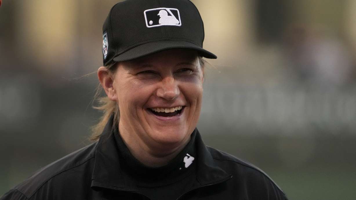 Umpire Jen Pawol smiles as she takes part in the lineup card exchange before the start of a spring training baseball game between the Washington Nationals and the Houston Astros Saturday, Feb. 24, 2024, in West Palm Beach, Fla. Pawol took a big step toward breaking the gender barrier for Major League Baseball umpires when she became the first woman in 17 years to work a big league spring training game Saturday night.