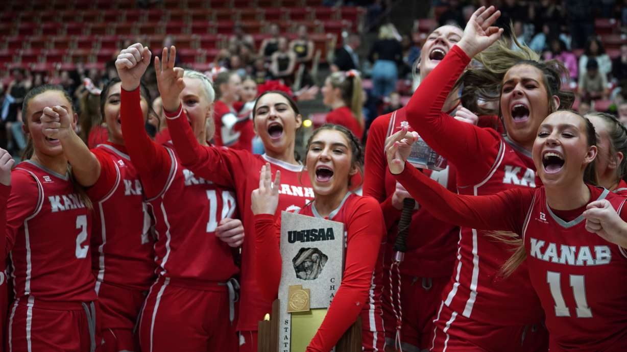 The Kanab girls basketball team celebrates with their championship trophy.
