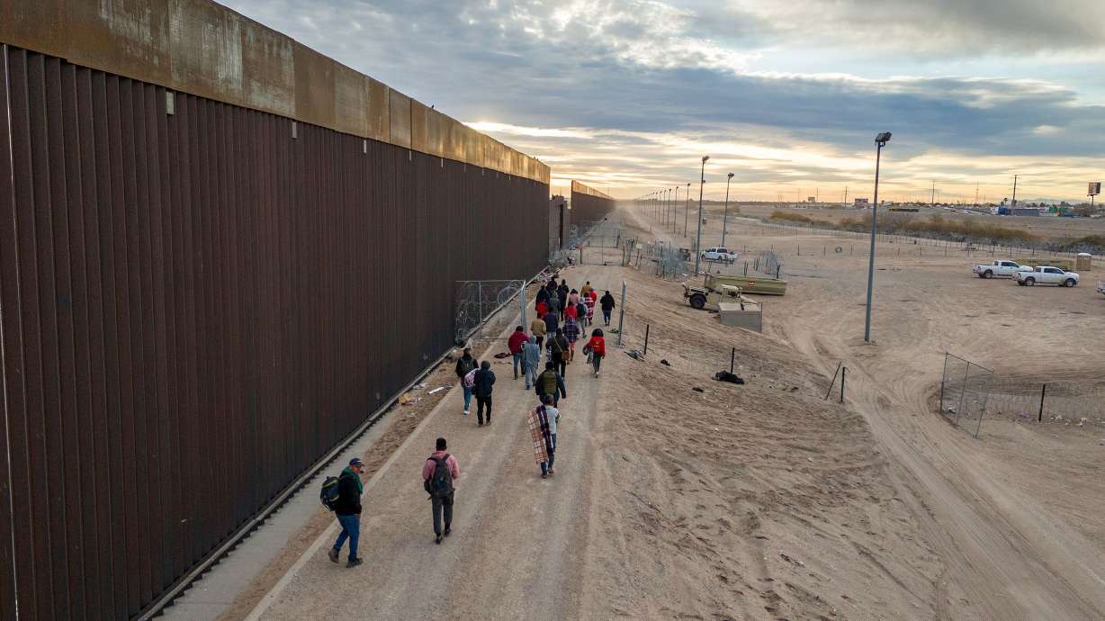 Migrants walk along the U.S.-Mexico border wall after crossing the Rio Grande into El Paso, Texas, from Ciudad Juarez, Mexico, on Feb. 1. Governors nationwide say managing immigration is a major issue.