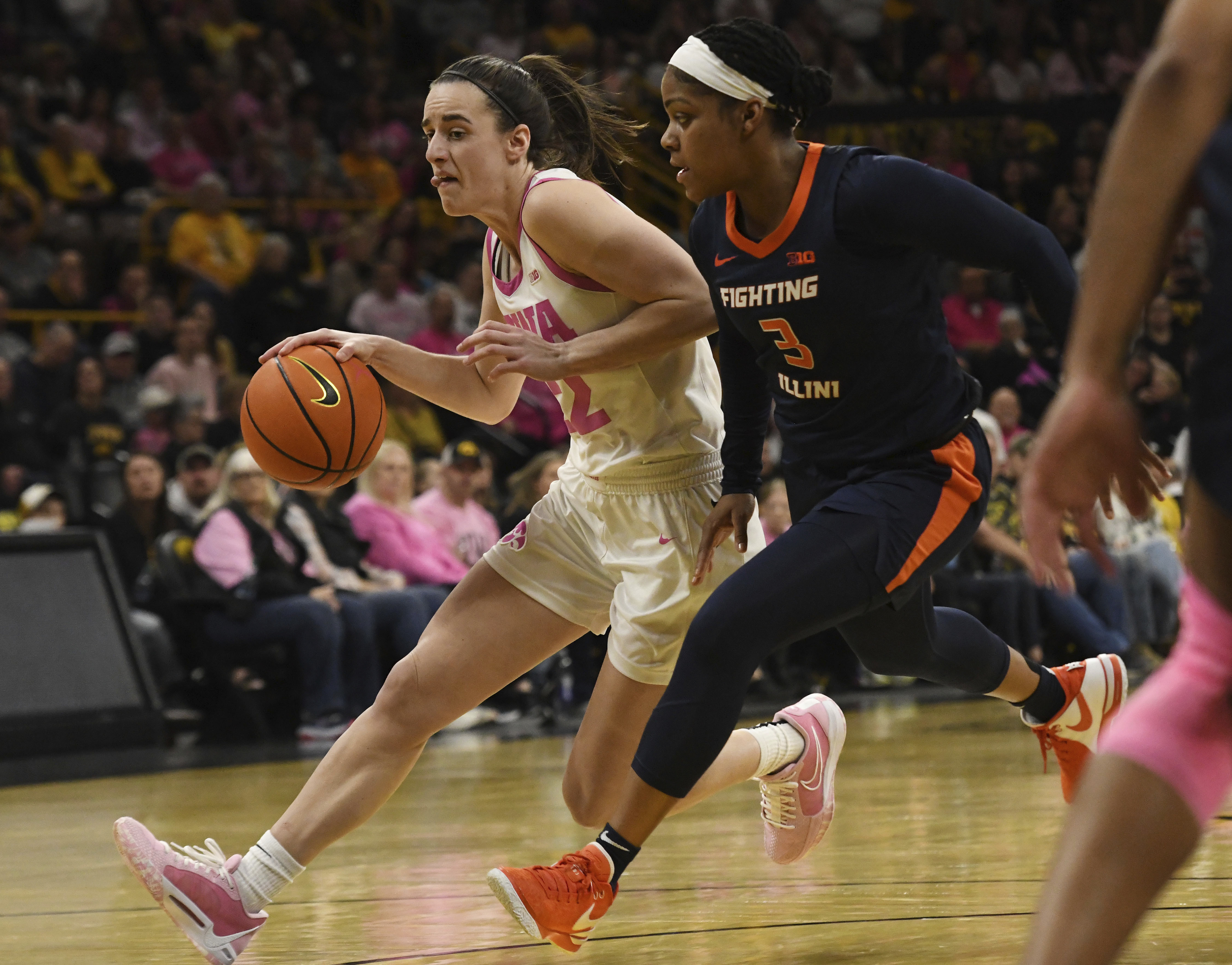 Iowa guard Caitlin Clark (22) drives to the basket under pressure from Illinois guard Makira Cook (3) during the second half of an NCAA college basketball game, Sunday, Feb. 25, 2024, in Iowa City, Iowa.