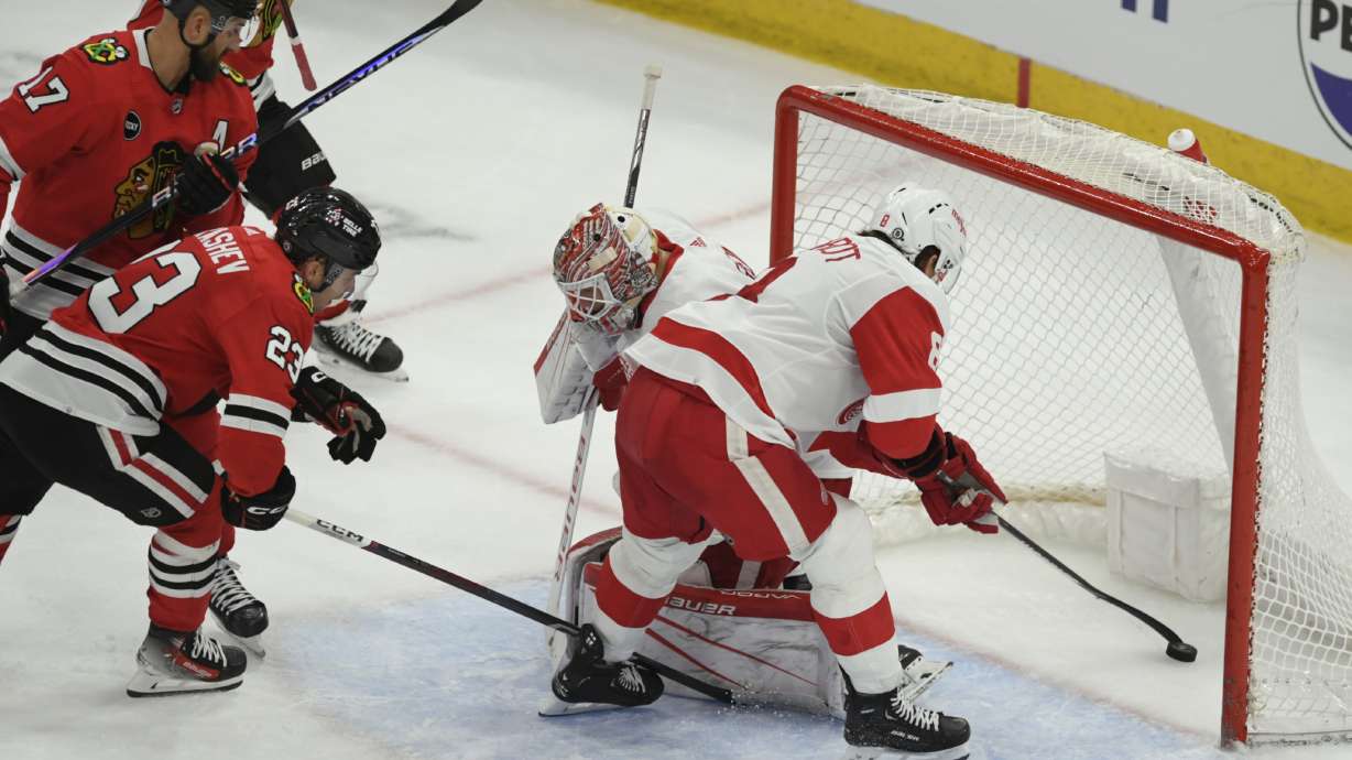 Detroit Red Wings' Ben Chiarot (8) and goalie James Reimer (47) attempt to stop a goal scored by Chicago Blackhawks' Nick Foligno (17) during the second period of an NHL hockey game Sunday, Feb. 25, 2024, in Chicago.