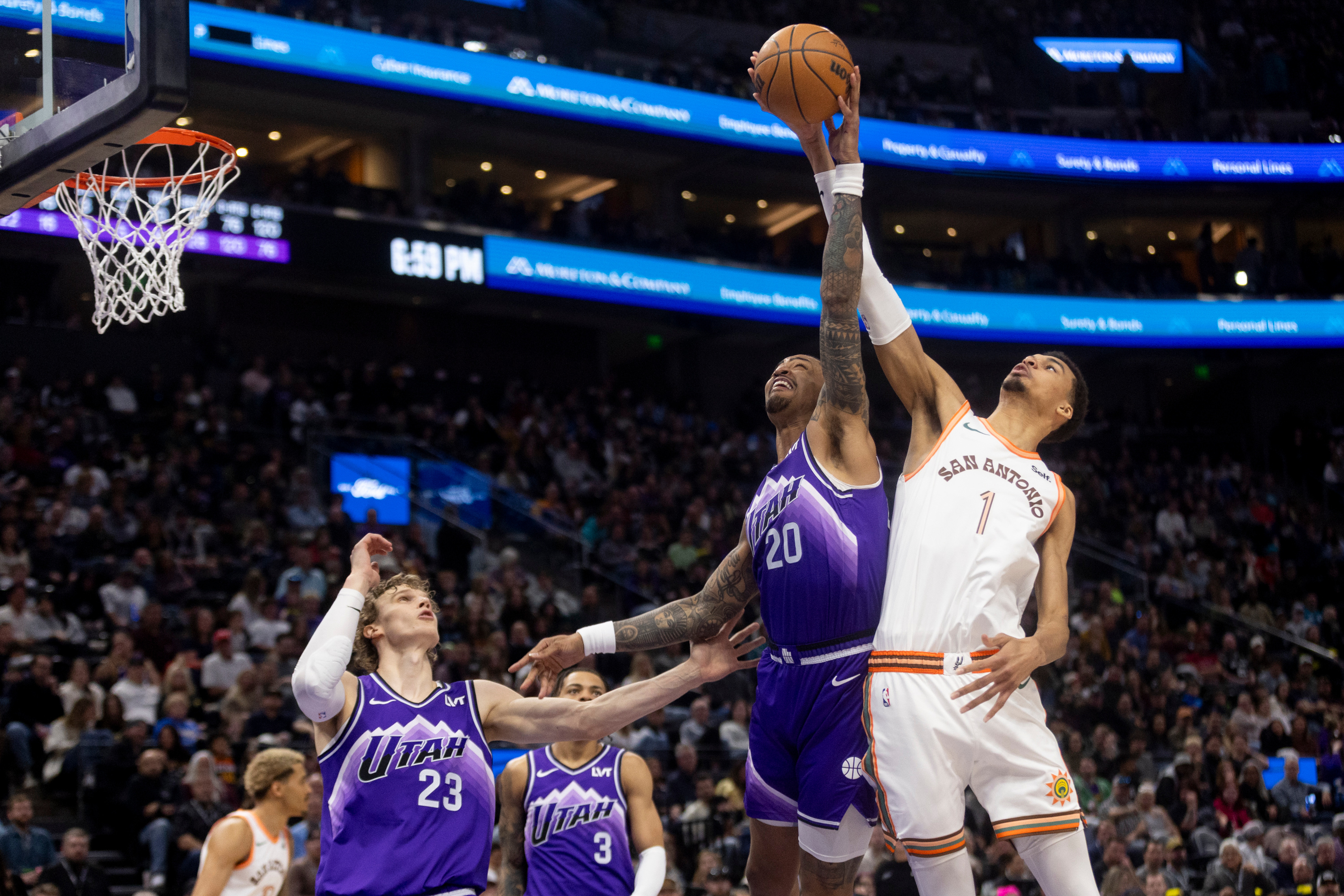 Utah Jazz forward John Collins (20) jumps to block San Antonio Spurs center Victor Wembanyama’s (1) shot during a game at the Delta Center in Salt Lake City on Sunday, Feb. 25, 2024.