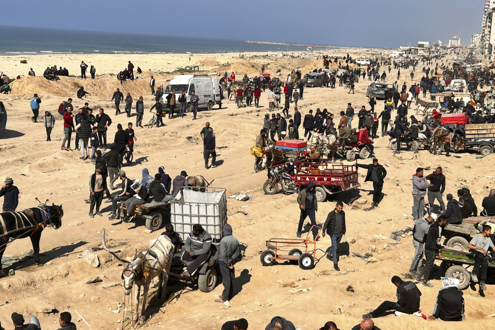 Palestinians wait for humanitarian aid on a beachfront in Gaza City, Gaza Strip, Sunday. President Joe Biden says he hopes a cease-fire between Israel and Hamas this weekend.