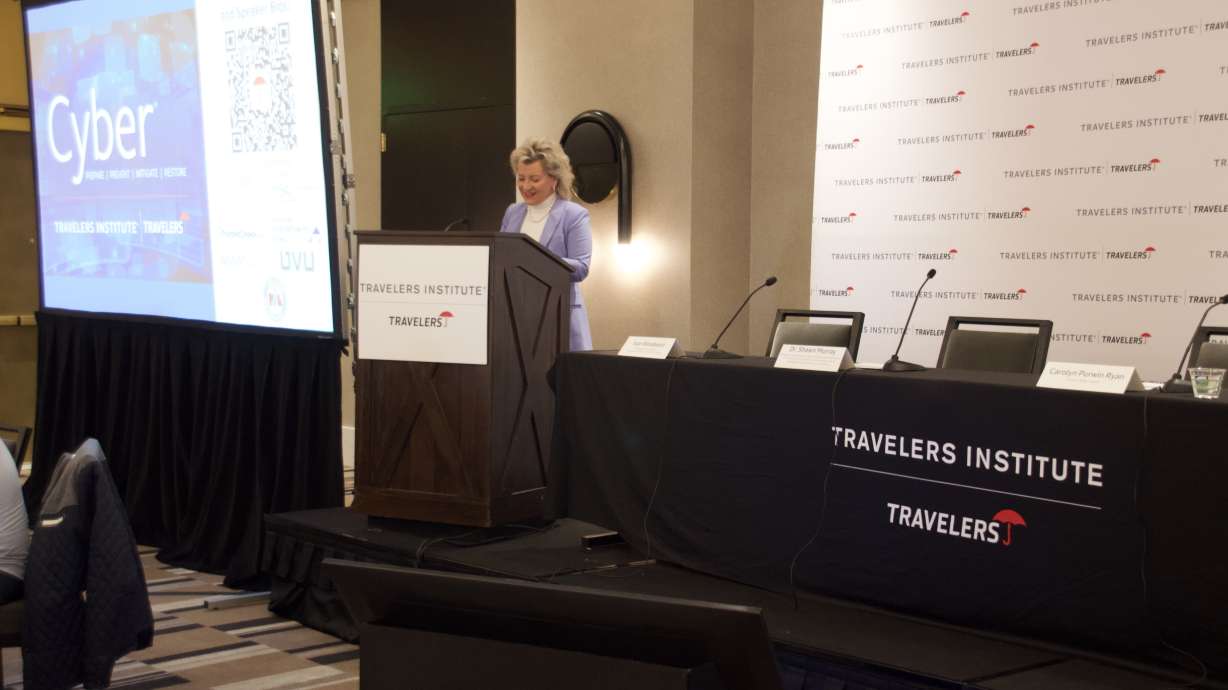 Joan Woodward, president of the Travelers Institute, welcomes the audience at a cybersecurity symposium held at the Le Méridien hotel in downtown Salt Lake City on Tuesday.
