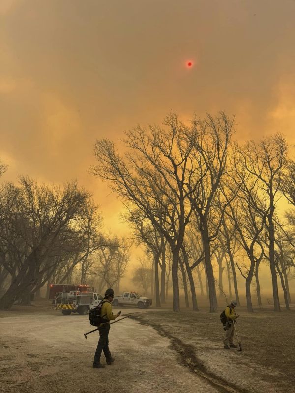 Flower Mound firefighters respond to a fire in the Texas Panhandle, Tuesday. A rapidly widening Texas wildfire doubled in size Tuesday and prompted evacuation orders in at least one small town.