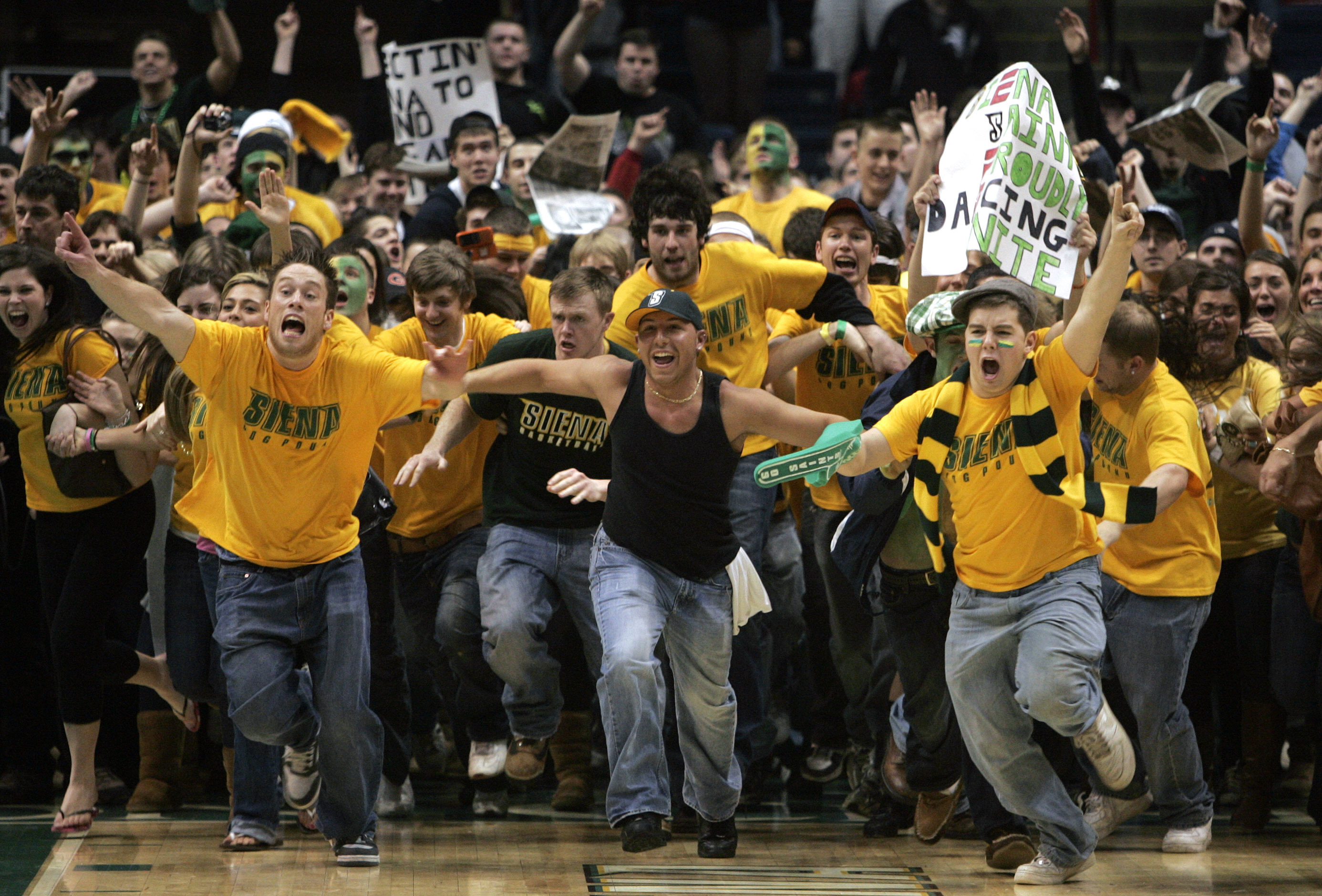 FILE - Siena fans storm the court after their team's 77-70 win over Niagara in the Metro Atlantic Athletic Conference NCAA college basketball championship game in Albany, N.Y., Monday, March 9, 2009. Recent incidents in college basketball have underscored the potential dangers that come from jubilant fans storming the court after the game comes to an end. Finding a solution is proving to be a challenge. 