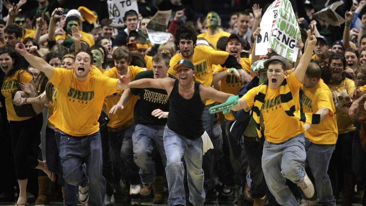 FILE - Siena fans storm the court after their team's 77-70 win over Niagara in the Metro Atlantic Athletic Conference NCAA college basketball championship game in Albany, N.Y., Monday, March 9, 2009. Recent incidents in college basketball have underscored the potential dangers that come from jubilant fans storming the court after the game comes to an end. Finding a solution is proving to be a challenge.