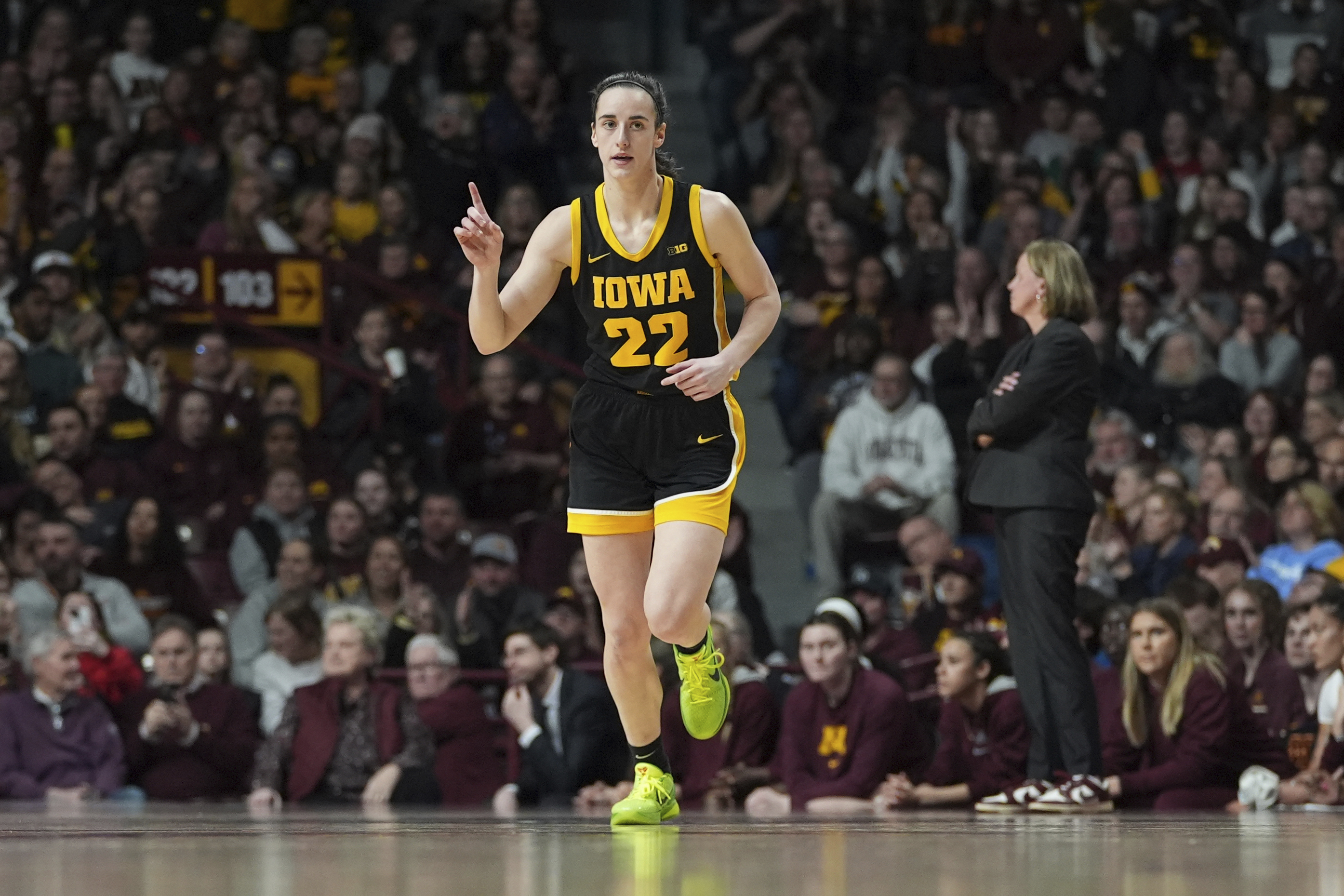 Iowa guard Caitlin Clark (22) points after an Iowa basket scored during the first half of an NCAA college basketball game against Minnesota, Wednesday, Feb. 28, 2024, in Minneapolis. 