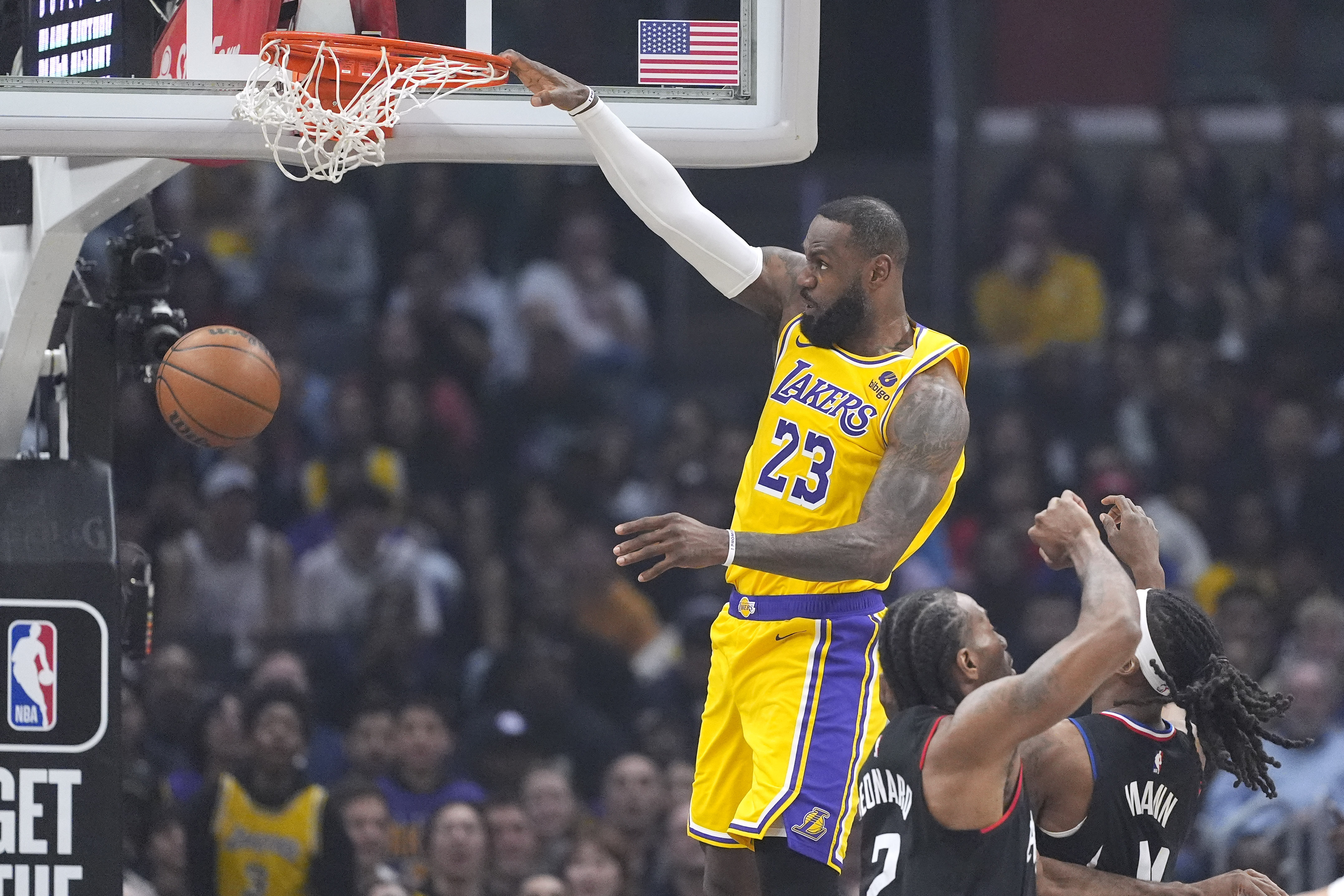 Los Angeles Lakers forward LeBron James, left, dunks as Los Angeles Clippers forward Kawhi Leonard, center, and guard Terance Mann defend during the first half of an NBA basketball game Wednesday, Feb. 28, 2024, in Los Angeles.