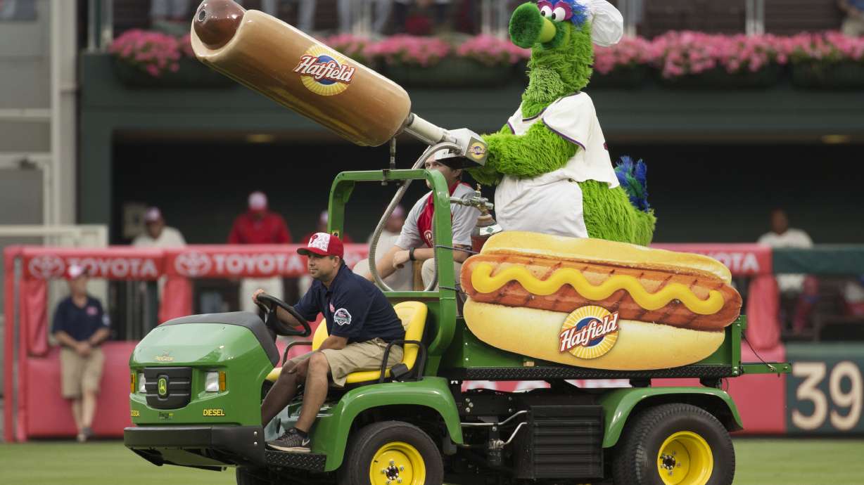 FILE - The Phillie Phanatic comes out with his Hot Dog Launcher during the fifth inning of a baseball game between the Atlanta Braves and the Philadelphia Phillies, Monday, July 4, 2016, in Philadelphia. For more than a quarter-century, Phillies fans thought dollar hot dog night was the best ballpark promotion — but the team has now decided it was the wurst.