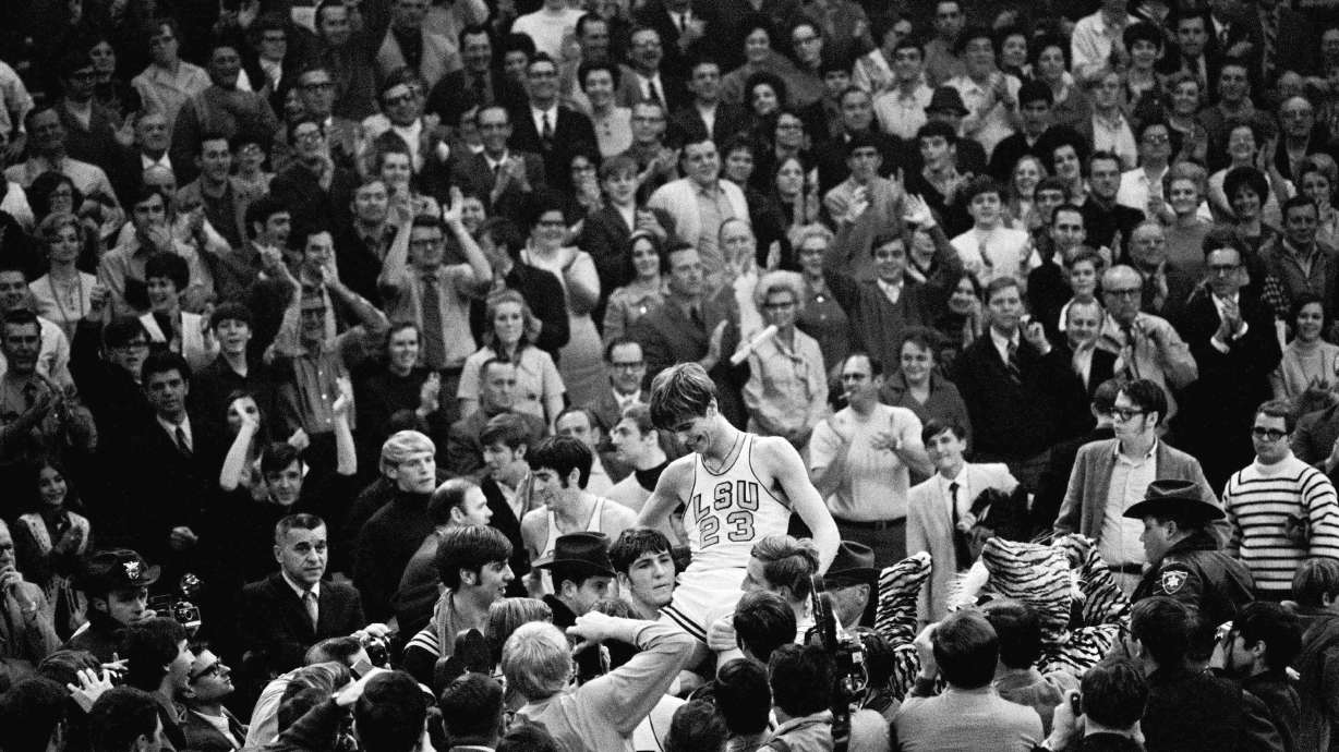 THIS CORRECTS THE DATE TO JAN. 31, 1970, NOT JAN. 28, 1979, AS ORIGINALLY SENT - - FILE - Pete Maravich (23) gets a boost from players and fans after he broke the all-time scoring record in Baton Rouge, La., Jan. 31, 1970. Calmly looking on at far left center is Pete's dad, Press, who coaches the Louisiana State Tigers. Those who played with, followed or knew the late Maravich are conflicted about the seemingly inevitable moment — likely this Sunday — when he could be supplanted by Iowa women's basketball sensation Caitlin Clark atop the NCAA's all-time scoring list.