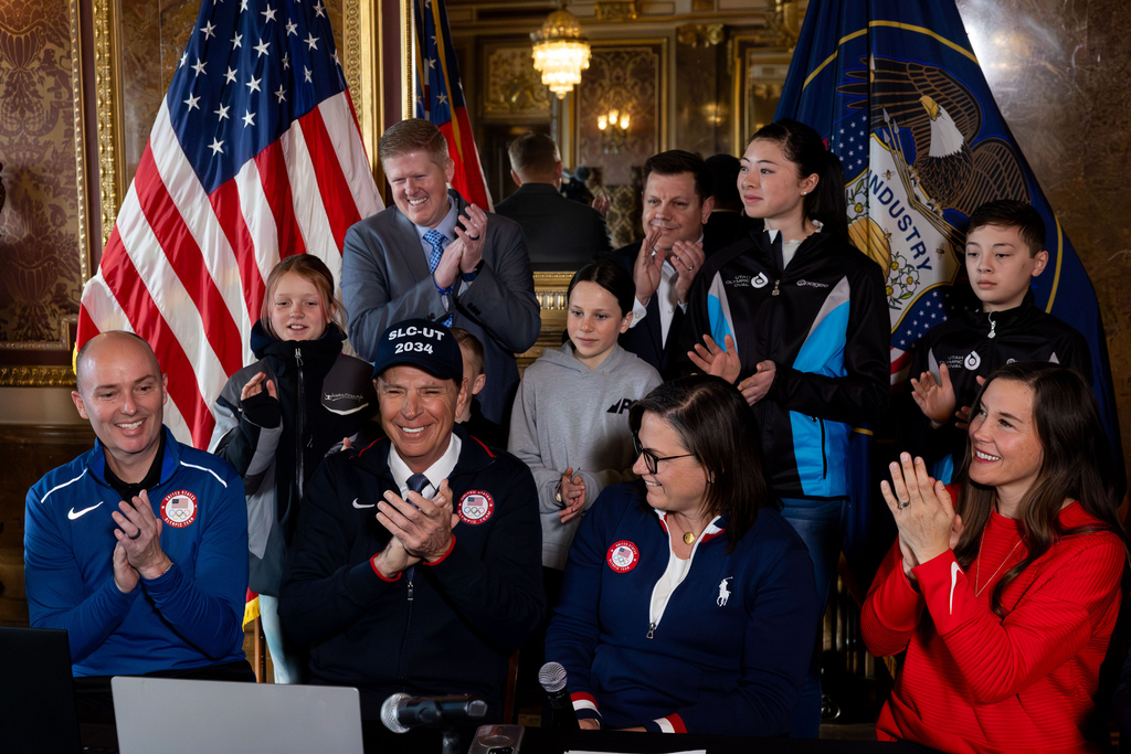 Leadership for the Salt Lake City-Utah Committee for the Games, including Salt Lake City Mayor Erin Mendenhall and Utah Gov. Spencer Cox, are joined by young athletes in applauding the official submission of Utah’s bid at a strategic board meeting for the Salt Lake City-Utah 2034 Olympic Winter Games at the Utah Capitol in Salt Lake City on Thursday.