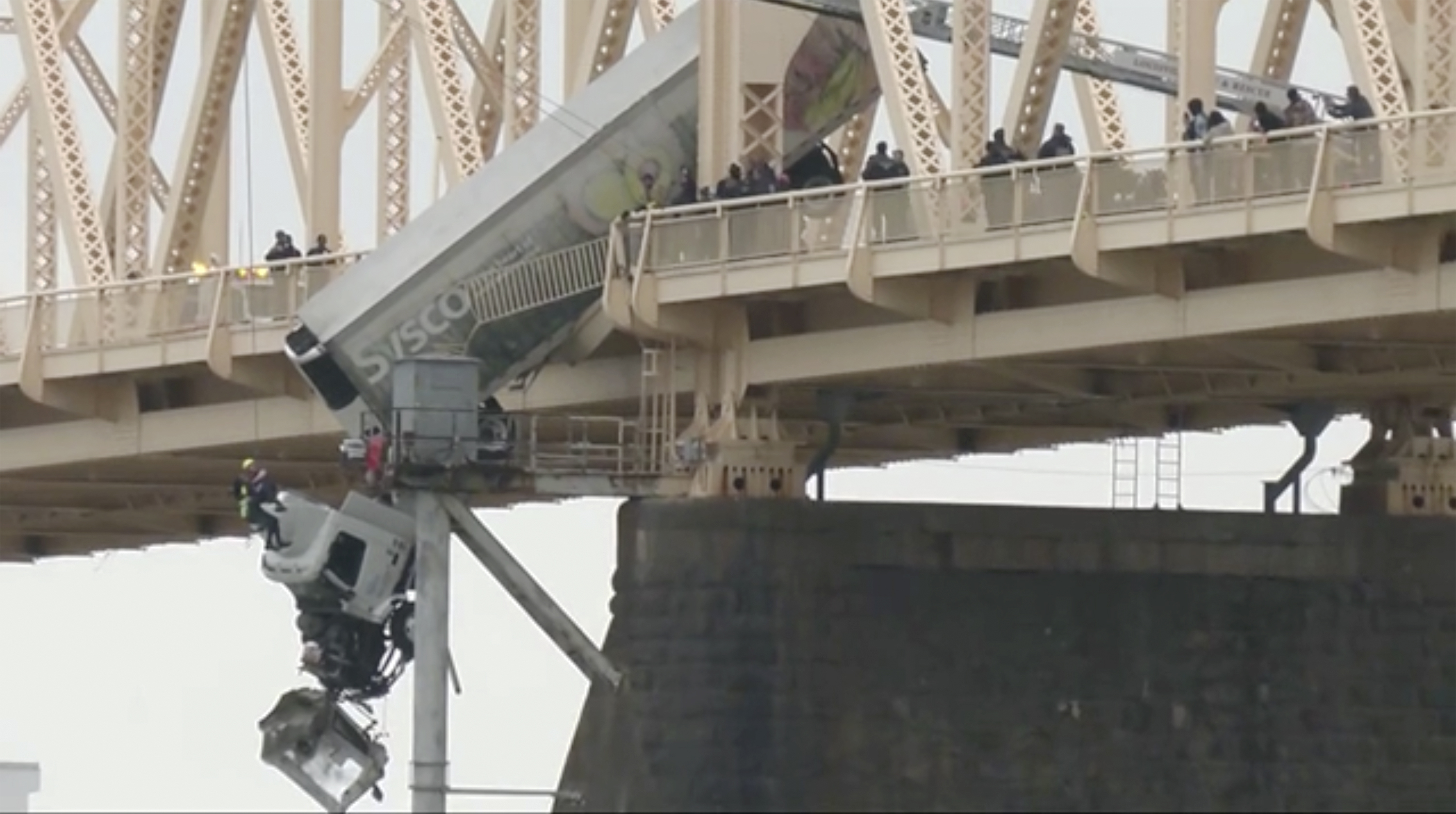 Louisville emergency crews rescue the driver of a semitruck that is dangling off the Clark Memorial Bridge over the Ohio River on Friday in Louisville, Ky. 
