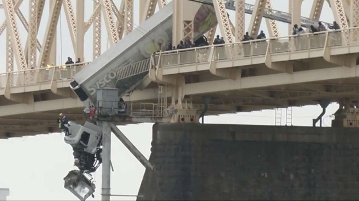 Louisville emergency crews rescue the driver of a semitruck that is dangling off the Clark Memorial Bridge over the Ohio River on Friday in Louisville, Ky.