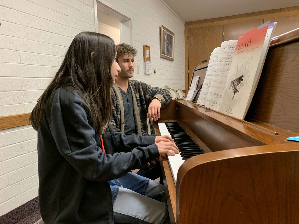 Tanner Knapp teaches piano to Alondra Soto at a Latter-day Saint meetinghouse in Provo being used as a community resource center on Tuesday.