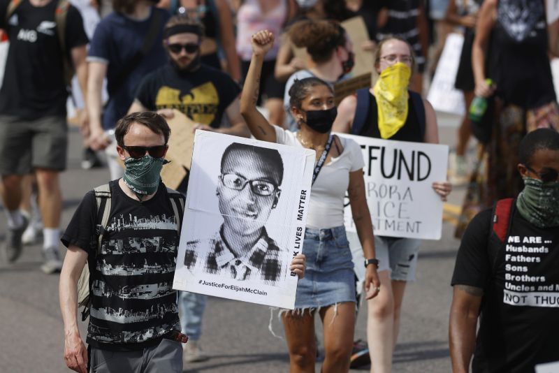Demonstrators walk down Sable Boulevard during a rally and march over the death of Elijah McClain in Aurora, Colo., June 27, 2020.
