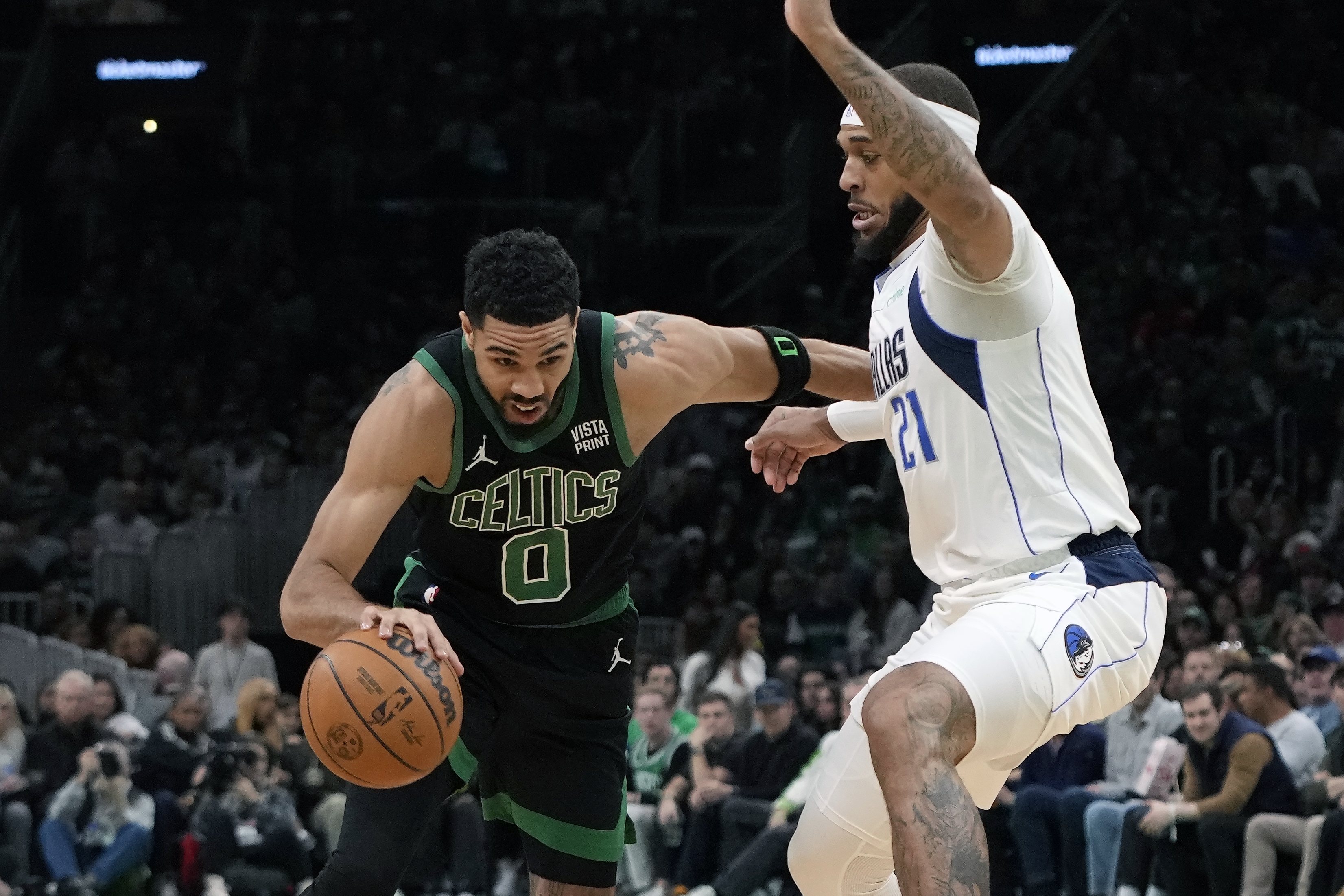 Boston Celtics' Jayson Tatum (0) drives past Dallas Mavericks' Daniel Gafford (21) during the first half of an NBA basketball game, Friday, March 1, 2024, in Boston.