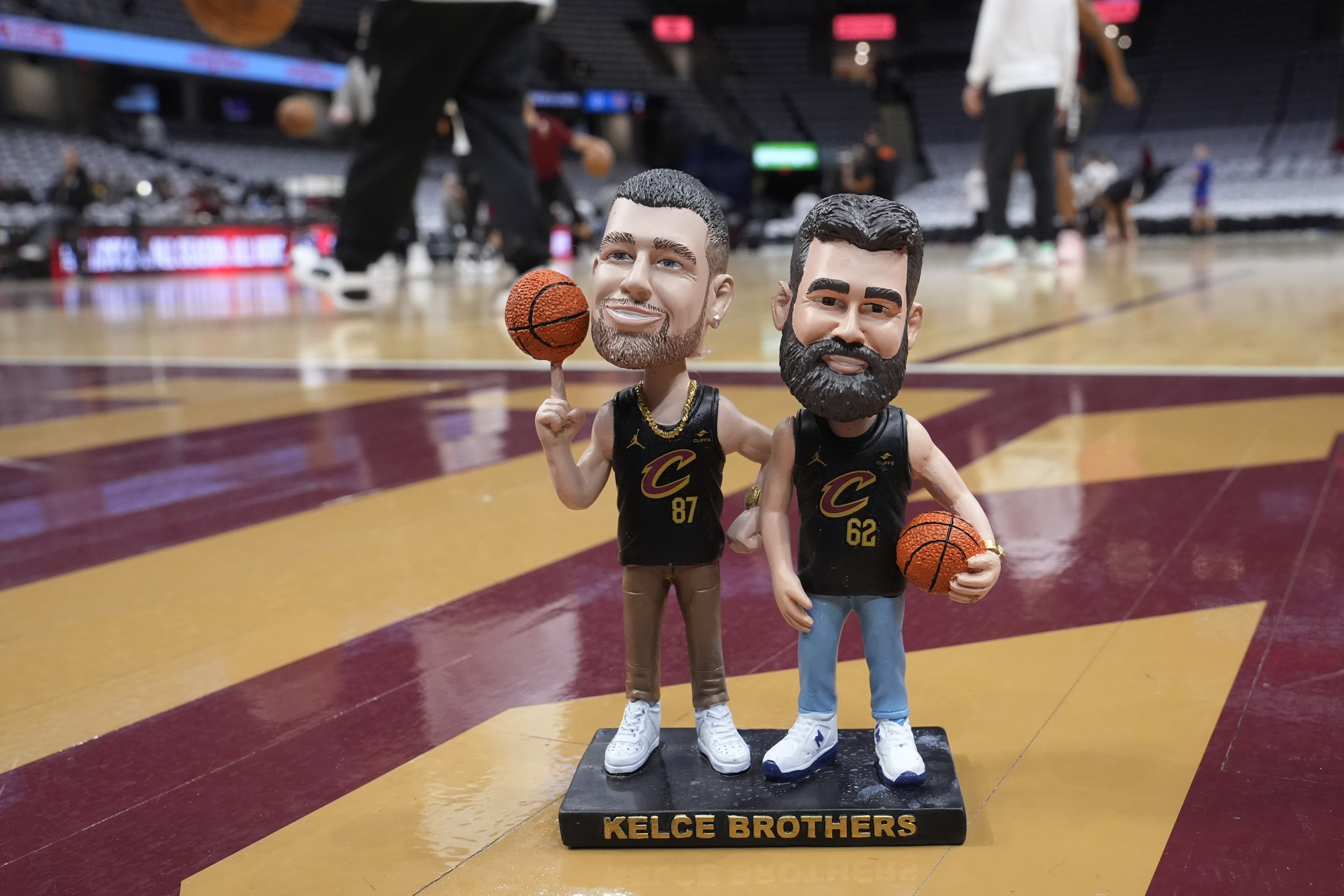 A bobblehead of Cleveland natives Travis and Jason Kelce stands on the Cleveland Cavaliers' court Sunday, March 3, 2024, in Cleveland. The team will give the bobbleheads to fans at an NBA basketball game against the Boston Celtics, Tuesday, March 5. 