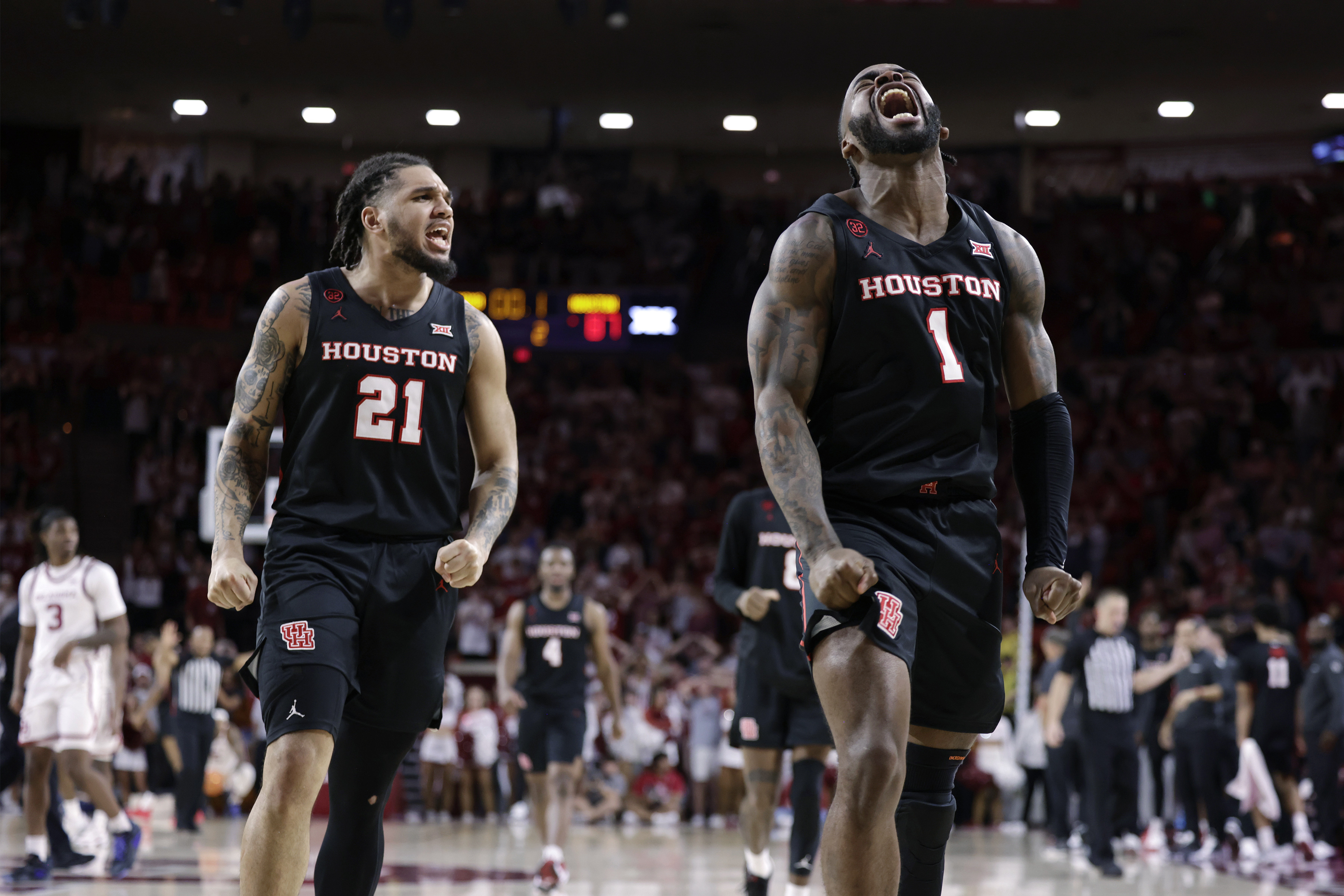 Houston guard Emanuel Sharp (21) and guard Jamal Shead (1) celebrate during the second half of the team's NCAA college basketball game against Oklahoma on Saturday, March 2, 2024, in Norman, Okla.