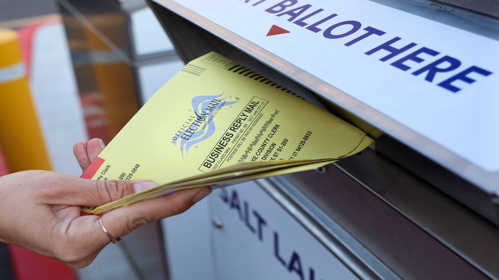 A voter places her ballot into a ballot drop box at the Salt Lake County Government Center in Salt Lake City on Nov. 21, 2023. Neighborhood precincts across the state will convene Tuesday night for their biennial party caucus. 
