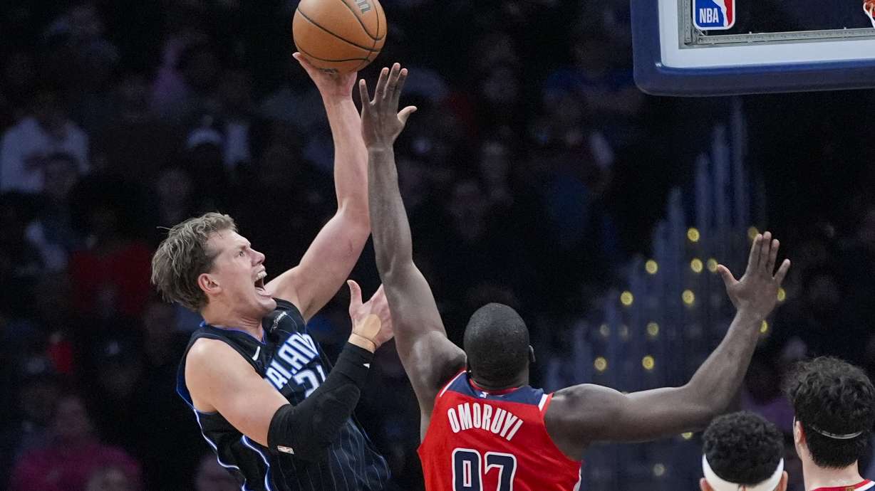 Orlando Magic center Moritz Wagner, left, shoots over Washington Wizards forward Eugene Omoruyi during the first half of an NBA basketball game Wednesday, March 6, 2024, in Washington.