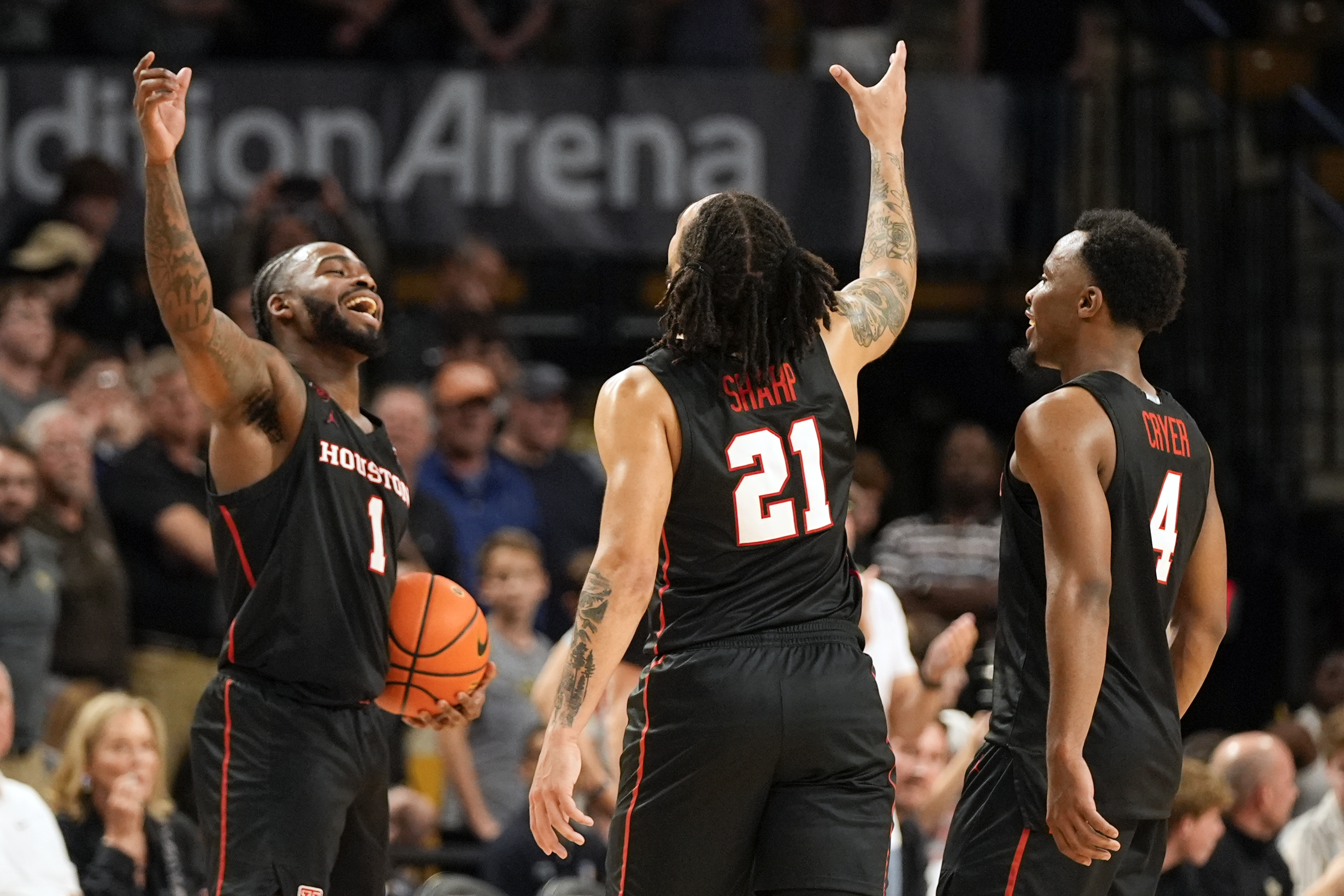 Houston guard Jamal Shead (1), guard Emanuel Sharp (21) and guard L.J. Cryer (4) celebrate the team's win over Central Florida in an NCAA college basketball game Wednesday, March 6, 2024, in Orlando, Fla. 