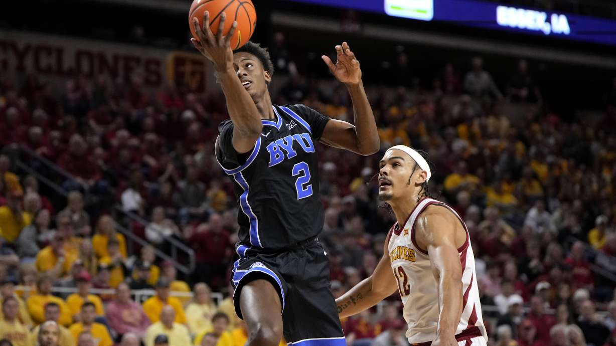 BYU guard Jaxson Robinson (2) gets past Iowa State forward Robert Jones (12) for basket during the first half of an NCAA college basketball game, Wednesday, March 6, 2024, in Ames, Iowa.