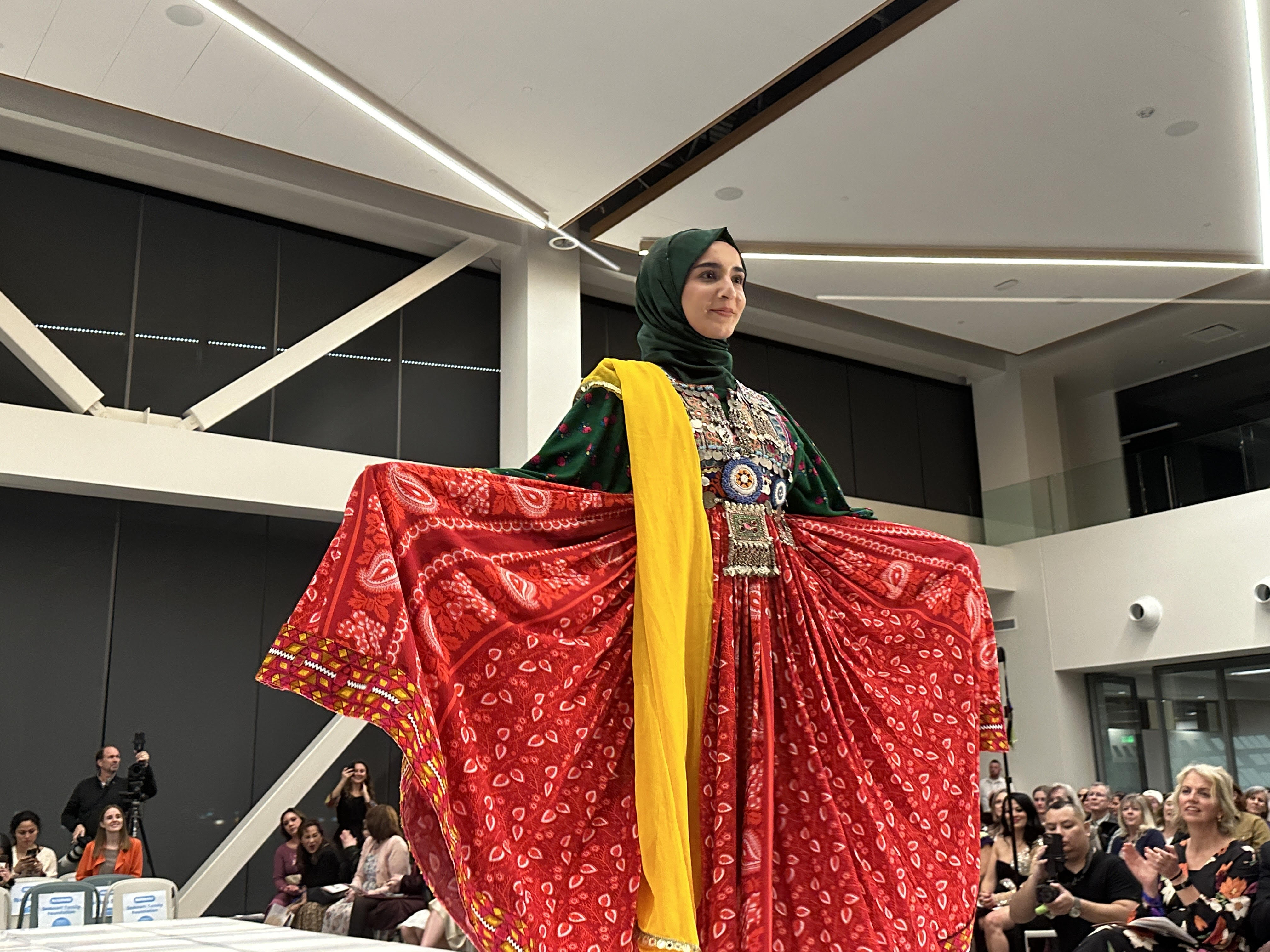 Naween Saeed, from Afganistan, shows off her colorful dress to the audience at the 14th annual Women of the World Fashion Show and Cultural Gala held Wednesday at the Zions Bancorporation Technology Center in Midvale.