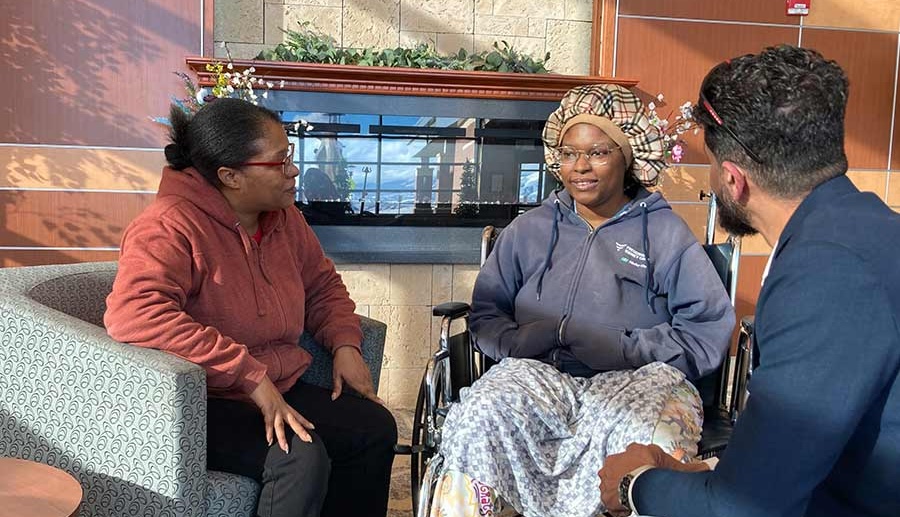 Britnay Campbell-Martin, center, sits with her mother, Vicki Martin, left, and Dr. Fahim Rahim, in an undated photo. Campbell-Martin has been stuck in a hospital for months while her children await her arrival at their out-of-state home.