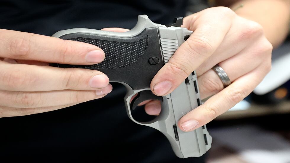 Aaron Varga, Doug’s Shoot’n Sports salesperson, does a paperwork check on a pistol that a customer is buying at Doug’s Shoot’n Sports in Taylorsville on Thursday.