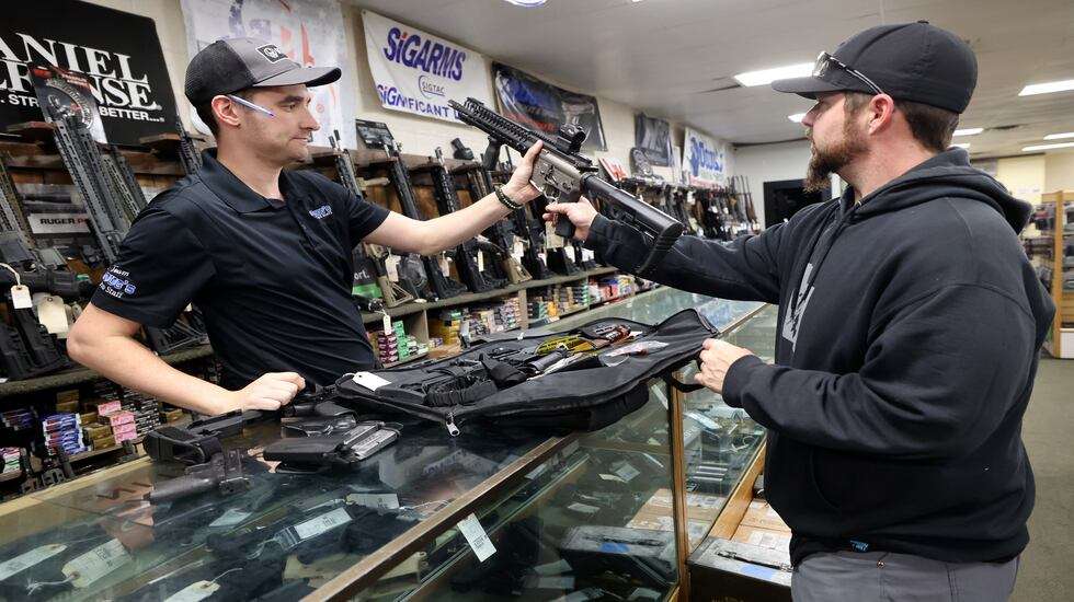 Aaron Varga, Doug’s Shoot’n Sports salesperson, helps Les Saibo pick out accessories for his AR-15 at Doug’s Shoot’n Sports in Taylorsville on Thursday. Saibo also ordered a new handgun at the shop.