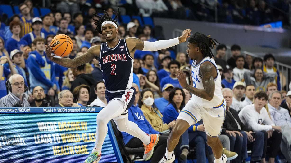 Arizona guard Caleb Love, left, grabs a loose ball against UCLA guard Dylan Andrews during the first half of an NCAA college basketball game in Los Angeles, Thursday, March 7, 2024.