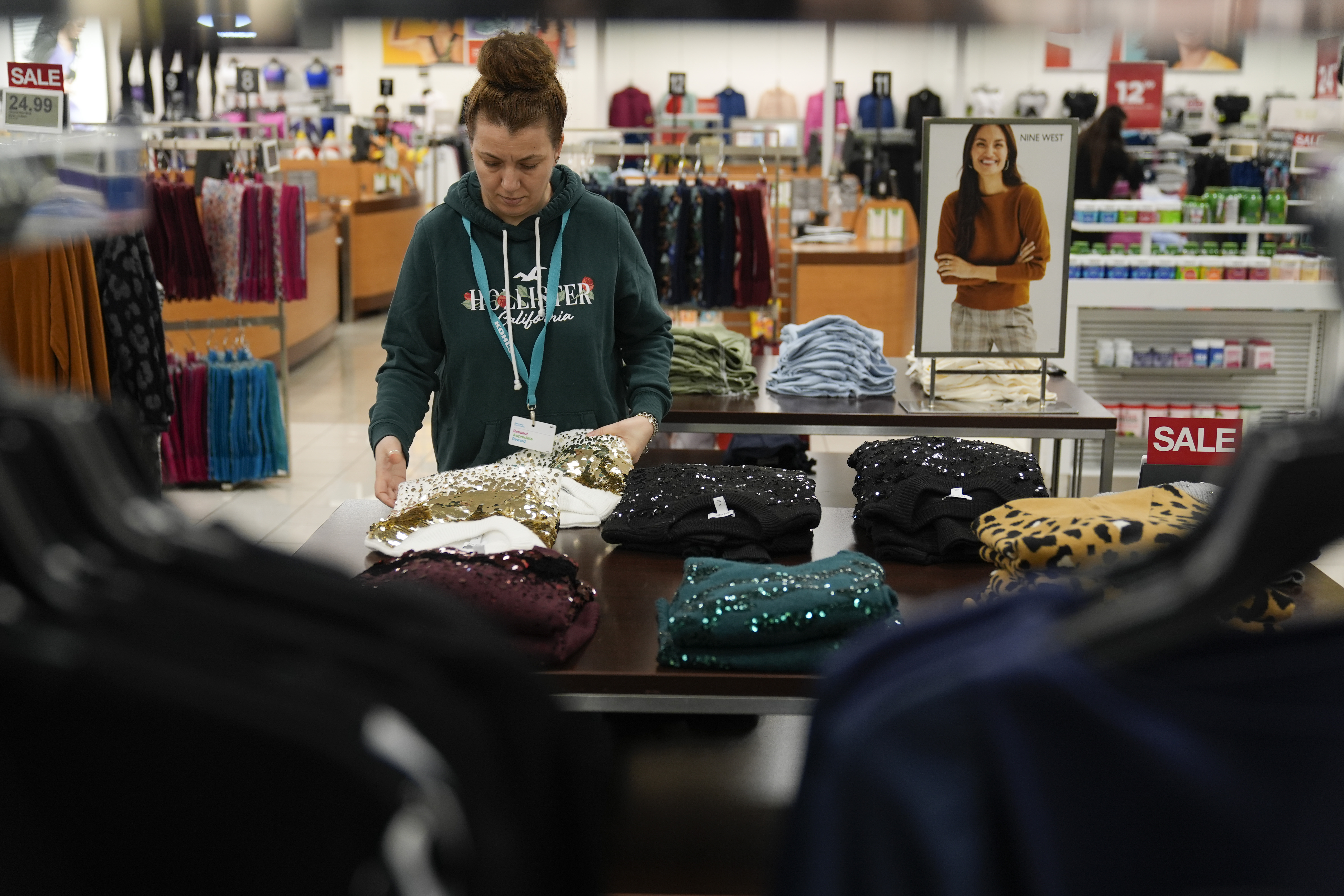 An employee straightens displays at a Kohl's store in Clifton, N.J., Jan. 26. America's employers delivered another healthy month of hiring in February, the government reported Friday.