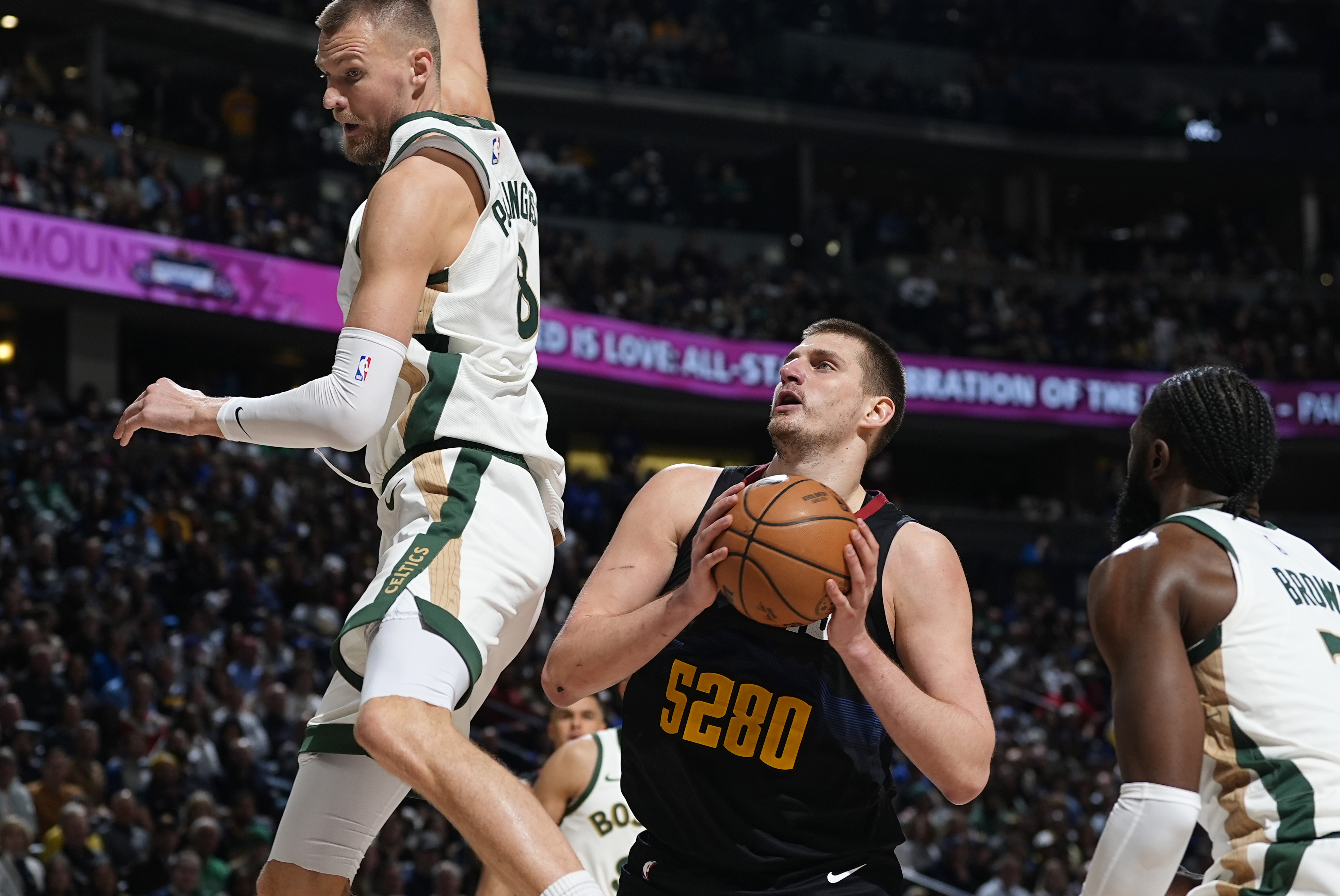 Denver Nuggets center Nikola Jokic looks for a shot as Boston Celtics center Kristaps Porzingis, left, and guard Jaylen Brown defend during the second half of an NBA basketball game Thursday, March 7, 2024, in Denver. 