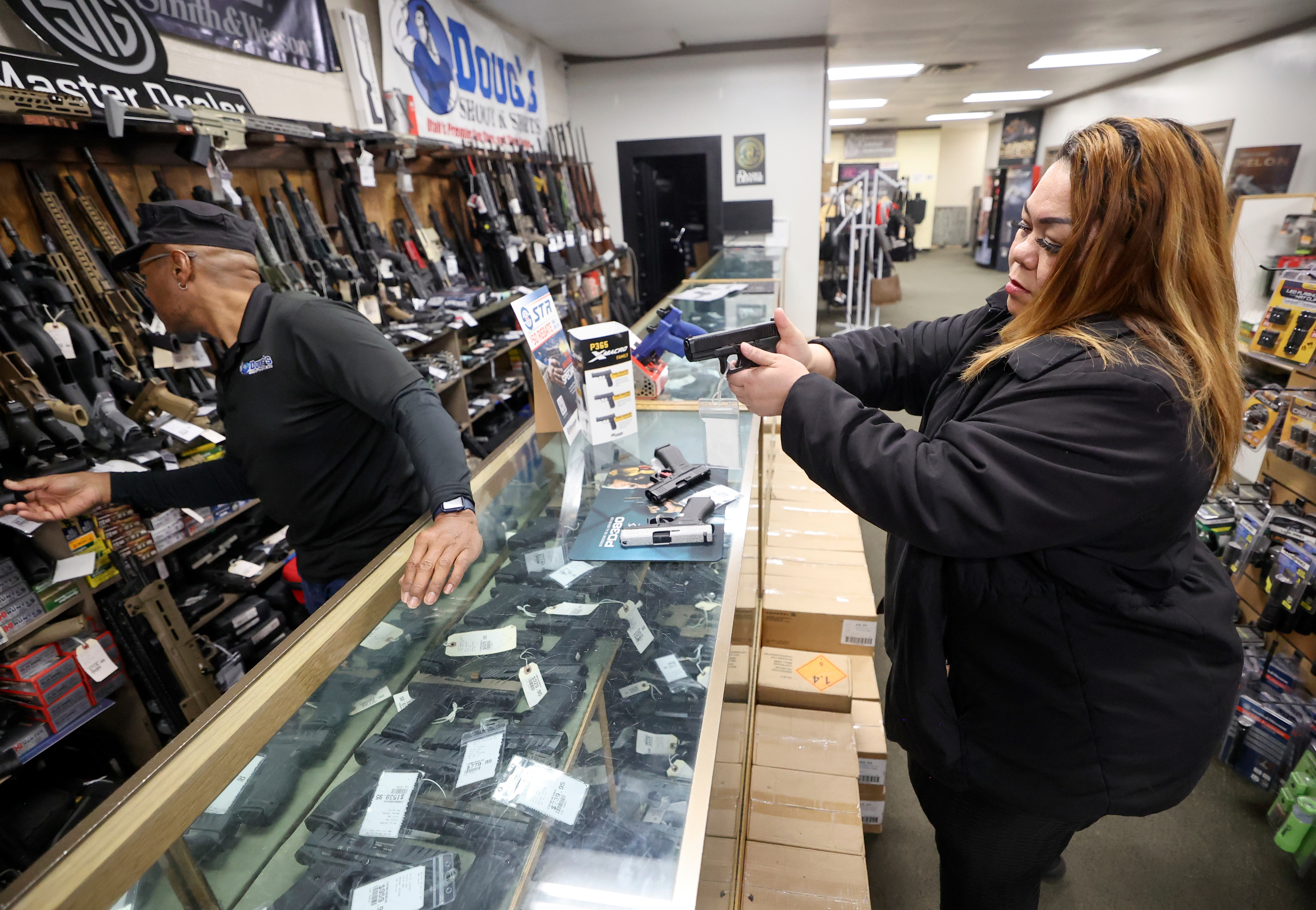 Burgess Griffin, Doug’s Shoot’n Sports salesman, helps Tea Olive as she shops for a handgun at Doug’s Shoot’n Sports in Taylorsville on Thursday. New legislation will prevent finance companies from tracking firearm sales in Utah.