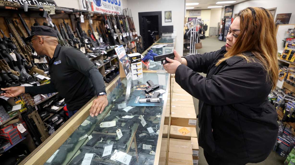Burgess Griffin, Doug’s Shoot’n Sports salesman, helps Tea Olive as she shops for a handgun at Doug’s Shoot’n Sports in Taylorsville on Thursday. New legislation will prevent finance companies from tracking firearm sales in Utah.