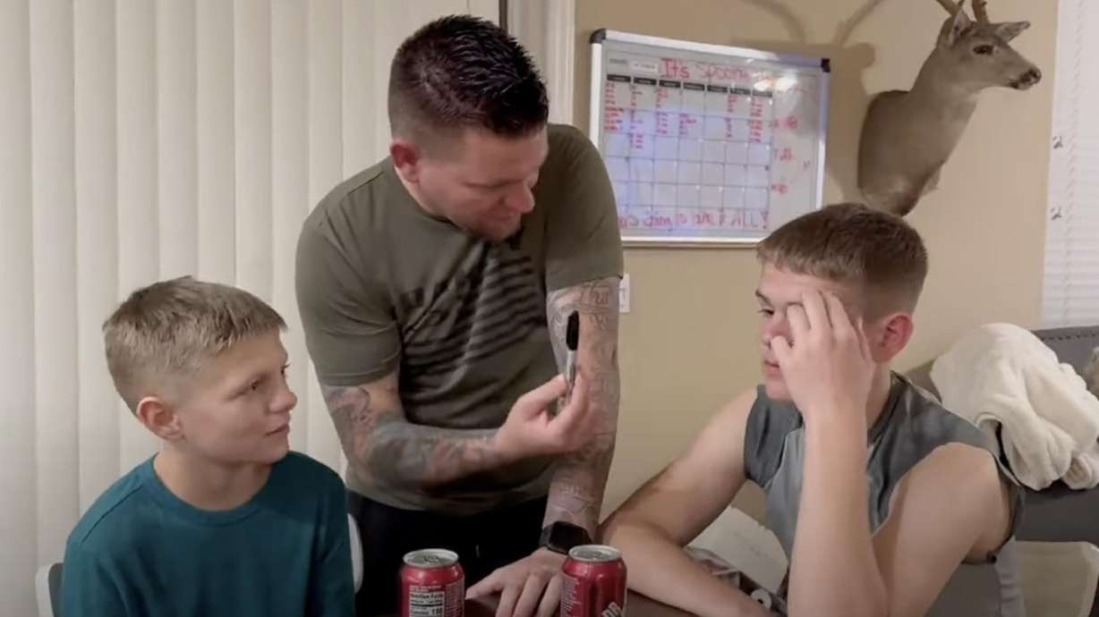 Dad challenges his sons to open a soda can using only a Sharpie. At the end of the video, he shows them how to do it.