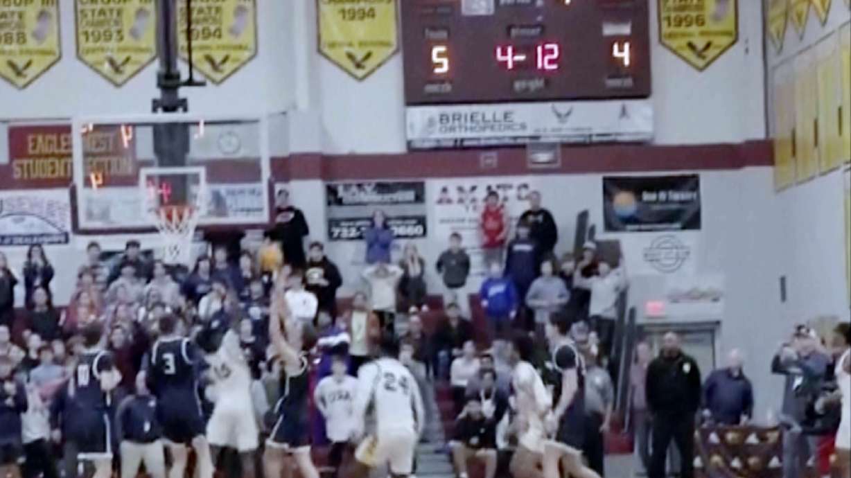 In this image taken from video provided by Joshua Clyburn, Manasquan's Griffin Linstra, center left, shoots as the clock winds down in the NJSIAA Group Tournament semifinal sound group 2 high school basketball game against Camden, Tuesday, March 5, 2024, in Berkley Township, N.J. Manasquan initially was declared the winner, however, the call was soon overturned when the referees discussed the shot and concluded it came after the buzzer, giving Camden a 46-45 win.