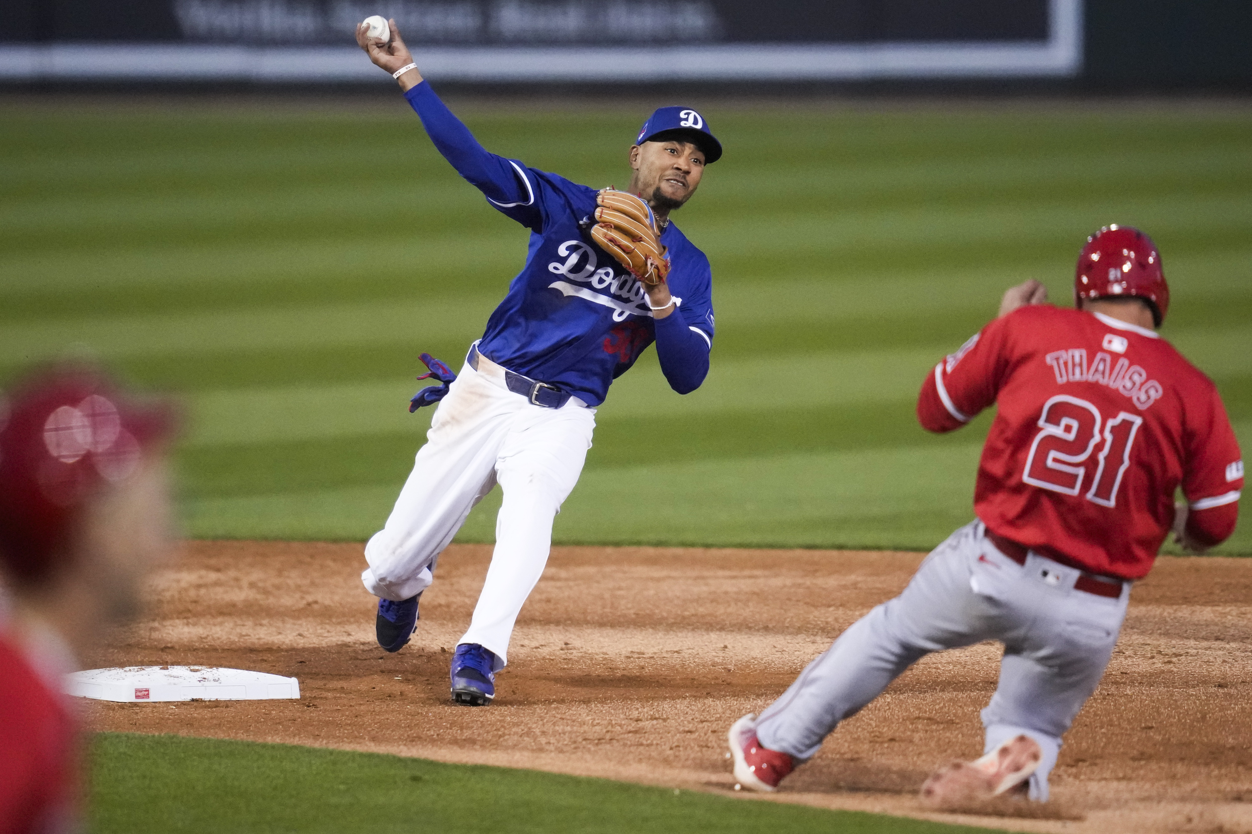 Los Angeles Dodgers second baseman Mookie Betts (50) throws to first as Los Angeles Angels' Zach Neto grounds in to a force out during the third inning of a spring training baseball game in Phoenix, Tuesday, March 5, 2024. Los Angeles Angels' Matt Thaiss (21) was out at second. 