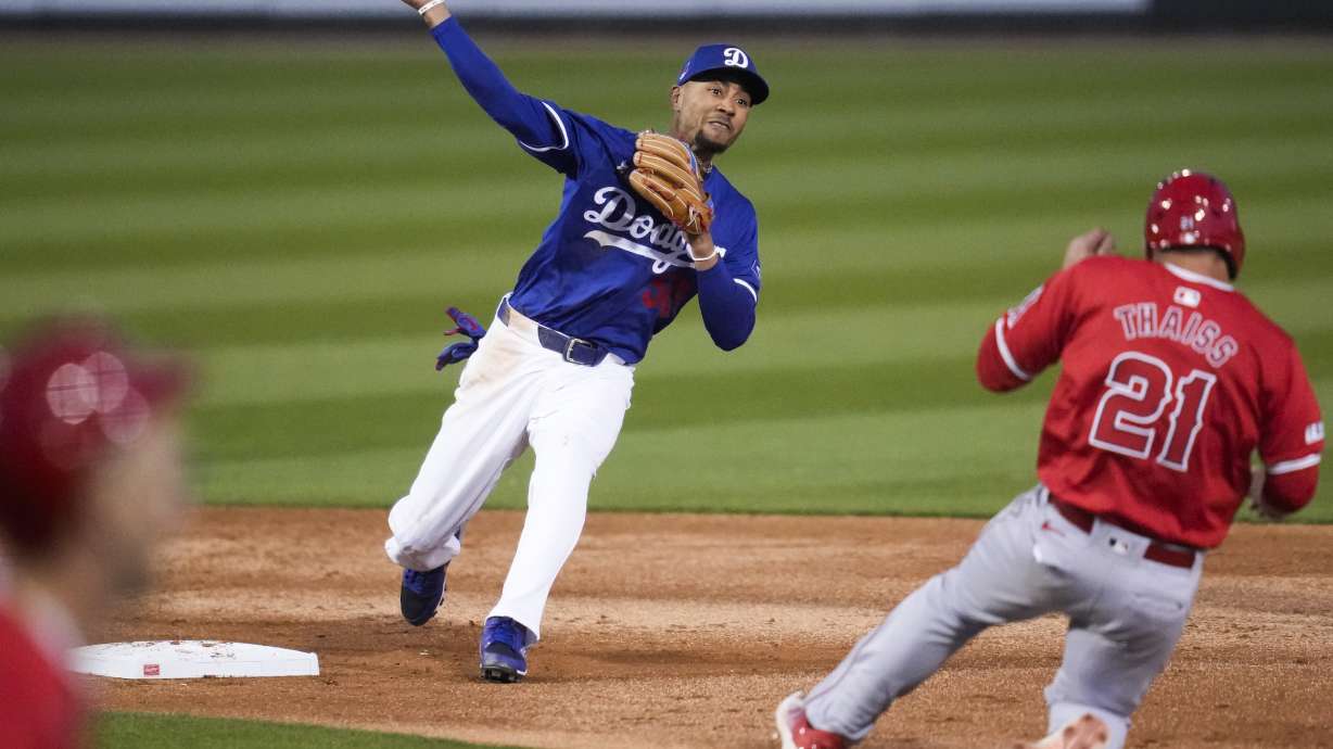 Los Angeles Dodgers second baseman Mookie Betts (50) throws to first as Los Angeles Angels' Zach Neto grounds in to a force out during the third inning of a spring training baseball game in Phoenix, Tuesday, March 5, 2024. Los Angeles Angels' Matt Thaiss (21) was out at second.