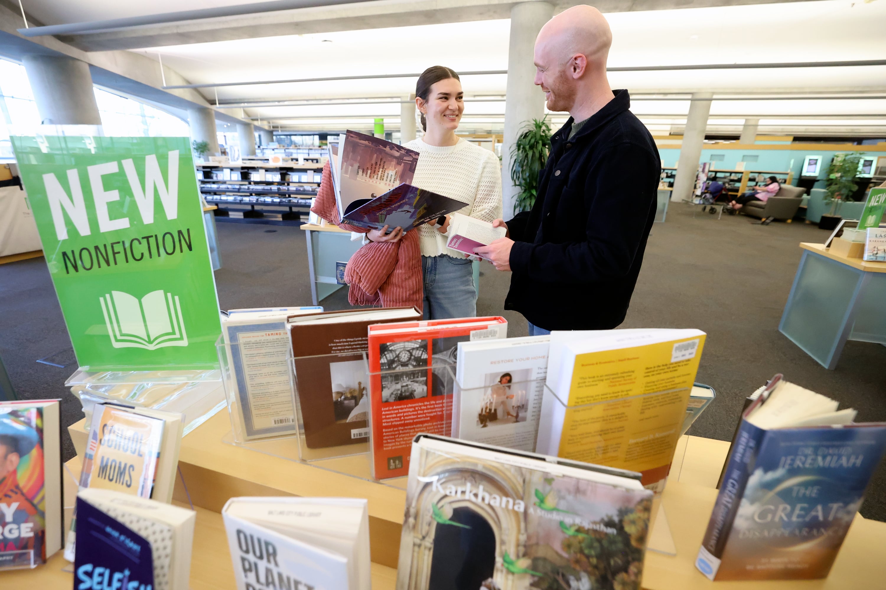 Malia Hansen and Scout Callens look at books at the City Library in Salt Lake City on Friday.