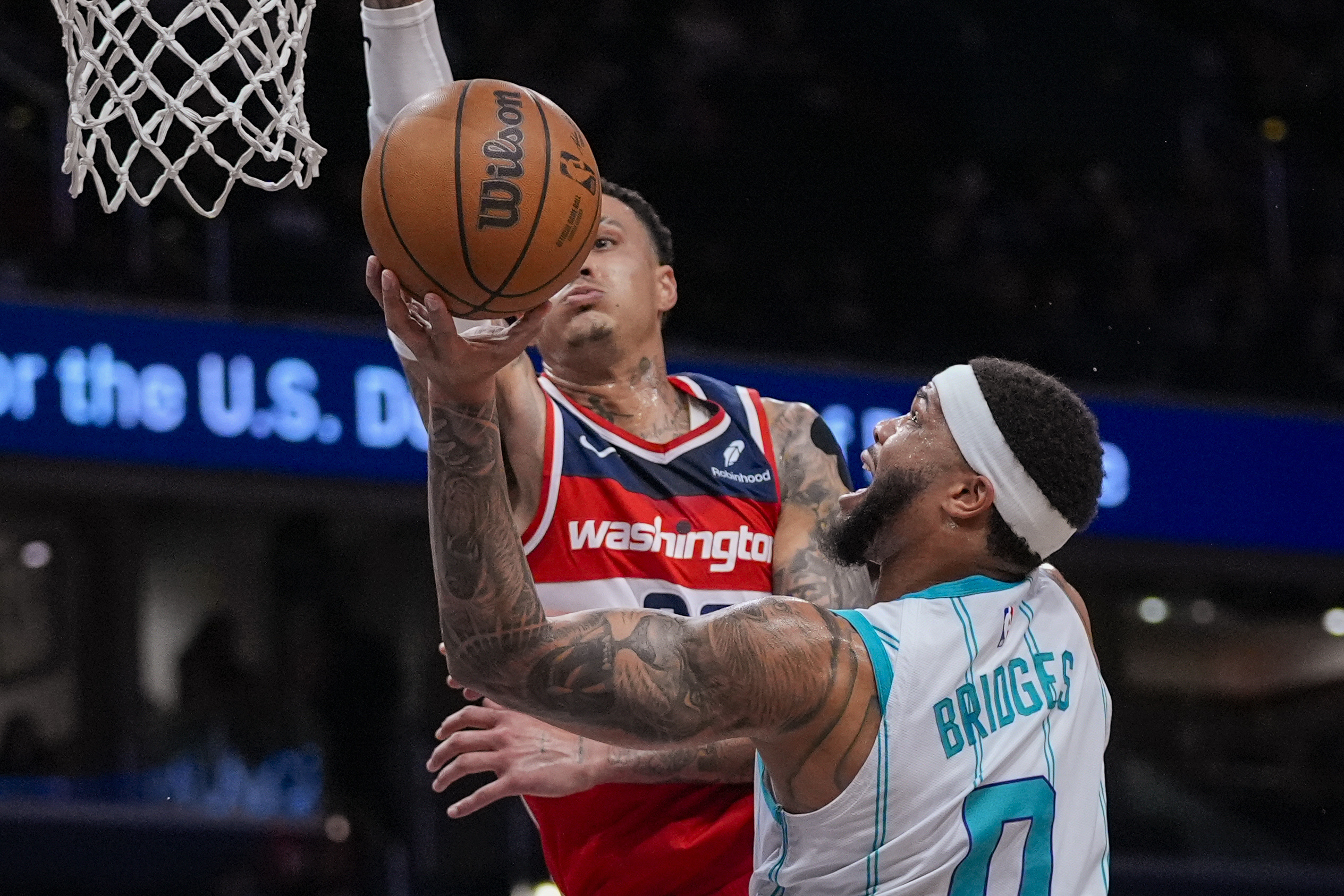 Washington Wizards forward Kyle Kuzma tries to block a shot by Charlotte Hornets forward Miles Bridges (0) during the first half of an NBA basketball game Friday, March 8, 2024, in Washington. 