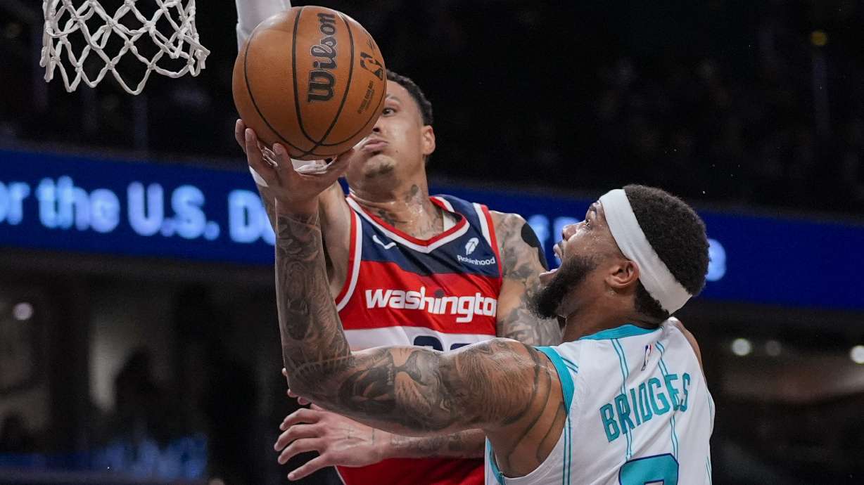 Washington Wizards forward Kyle Kuzma tries to block a shot by Charlotte Hornets forward Miles Bridges (0) during the first half of an NBA basketball game Friday, March 8, 2024, in Washington.