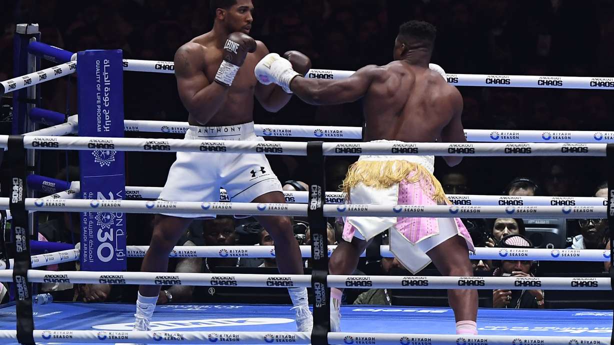 British former world champion Anthony Joshua, left, and MMA fighter Francis Ngannou fight during the heavyweight boxing showdown at Kingdom Arena in Riyadh, Saudi Arabia, Saturday, March 9, 2024.